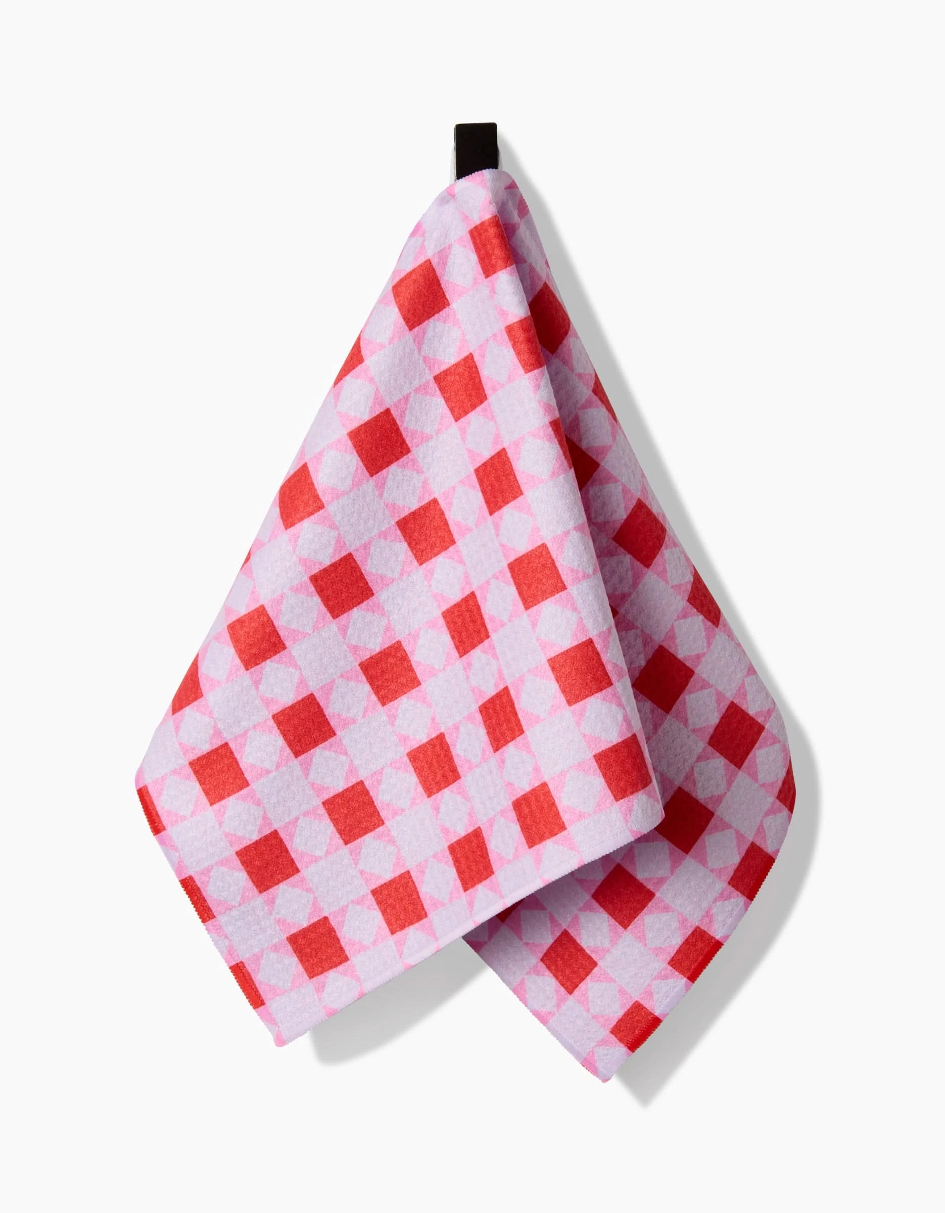 The Quilt Block Pink Andred bar towel by Brittany Jepsen, made from Geoweave fabric with a red and white checkered design, hangs from a black loop against a white background.