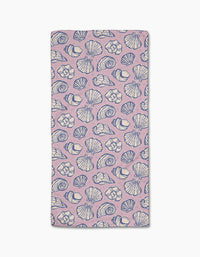 The Retro Coastal Seashells in Pink towel by Teri the Butter is a rectangular, light pink ultra-absorbent towel with blue and white seashell patterns on a white background.