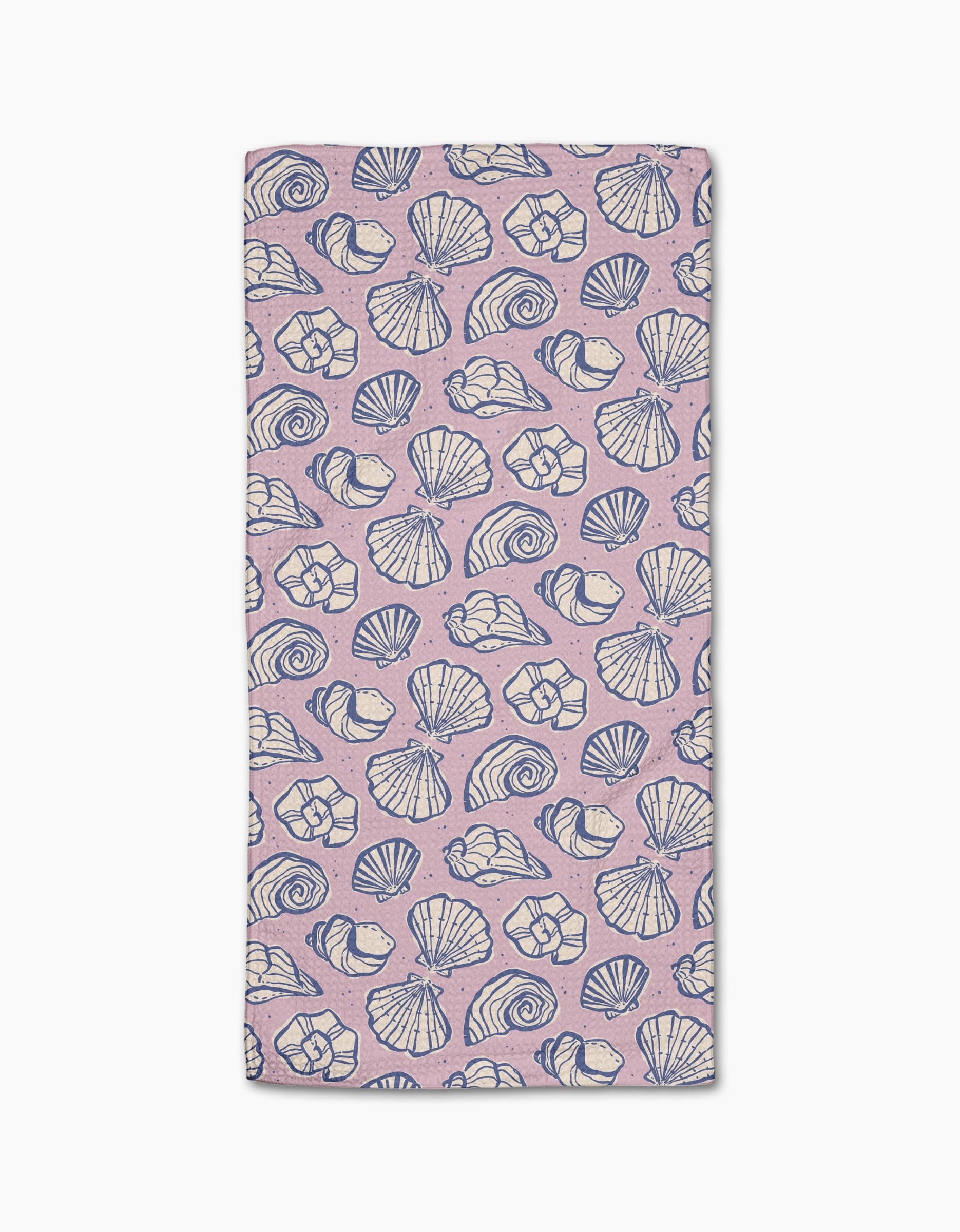 The Retro Coastal Seashells in Pink towel by Teri the Butter is a rectangular, light pink ultra-absorbent towel with blue and white seashell patterns on a white background.