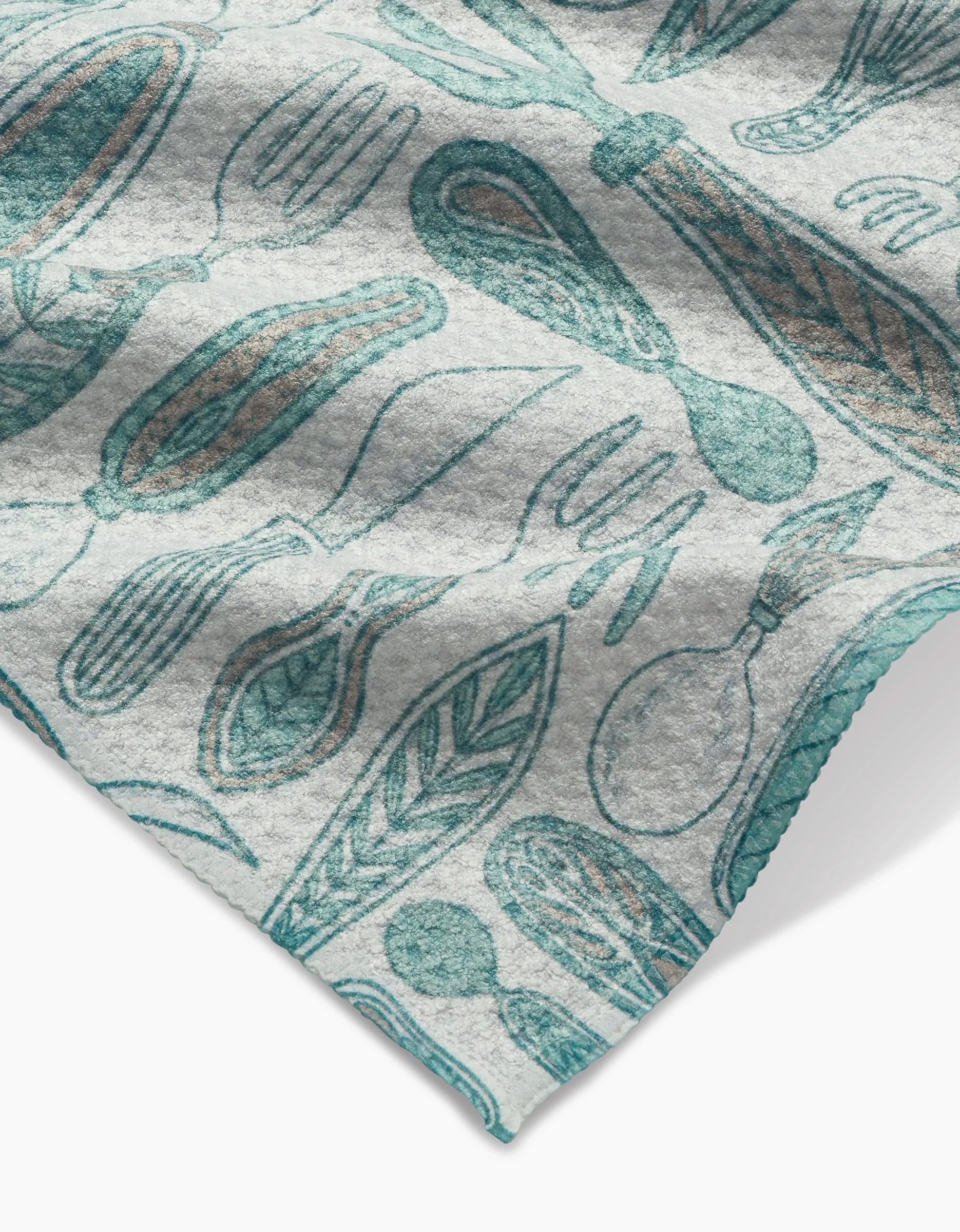 A close-up of the Romy bar towel by Amy MacCready, made with ultra-absorbent Geoweave fabric and featuring a blue and brown illustrated pattern of kitchen utensils and leaves on a light background.