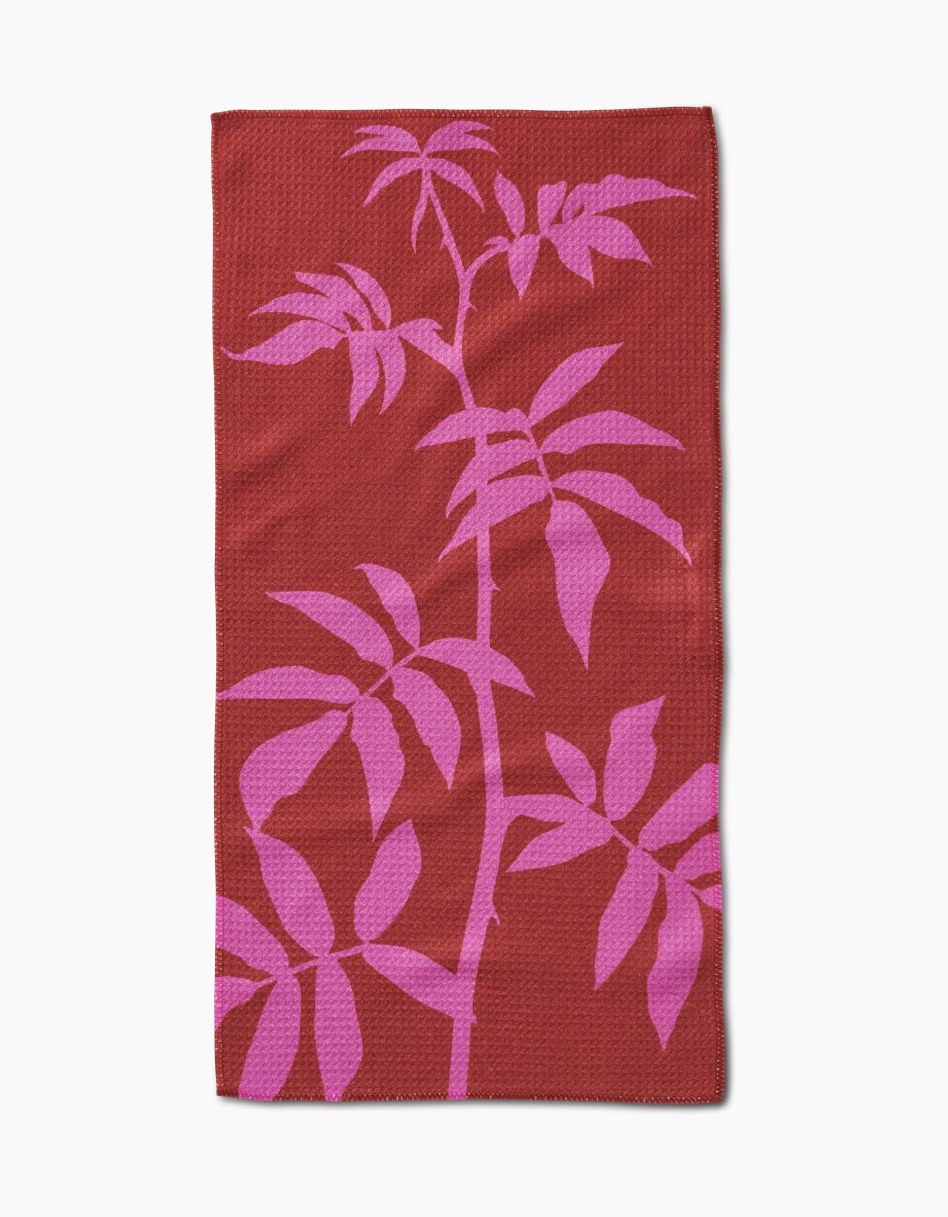 The PrintedPlant Rose towel is a rectangular red bar towel with a bold pink botanical leaf design across the surface, made from durable Geoweave fabric.
