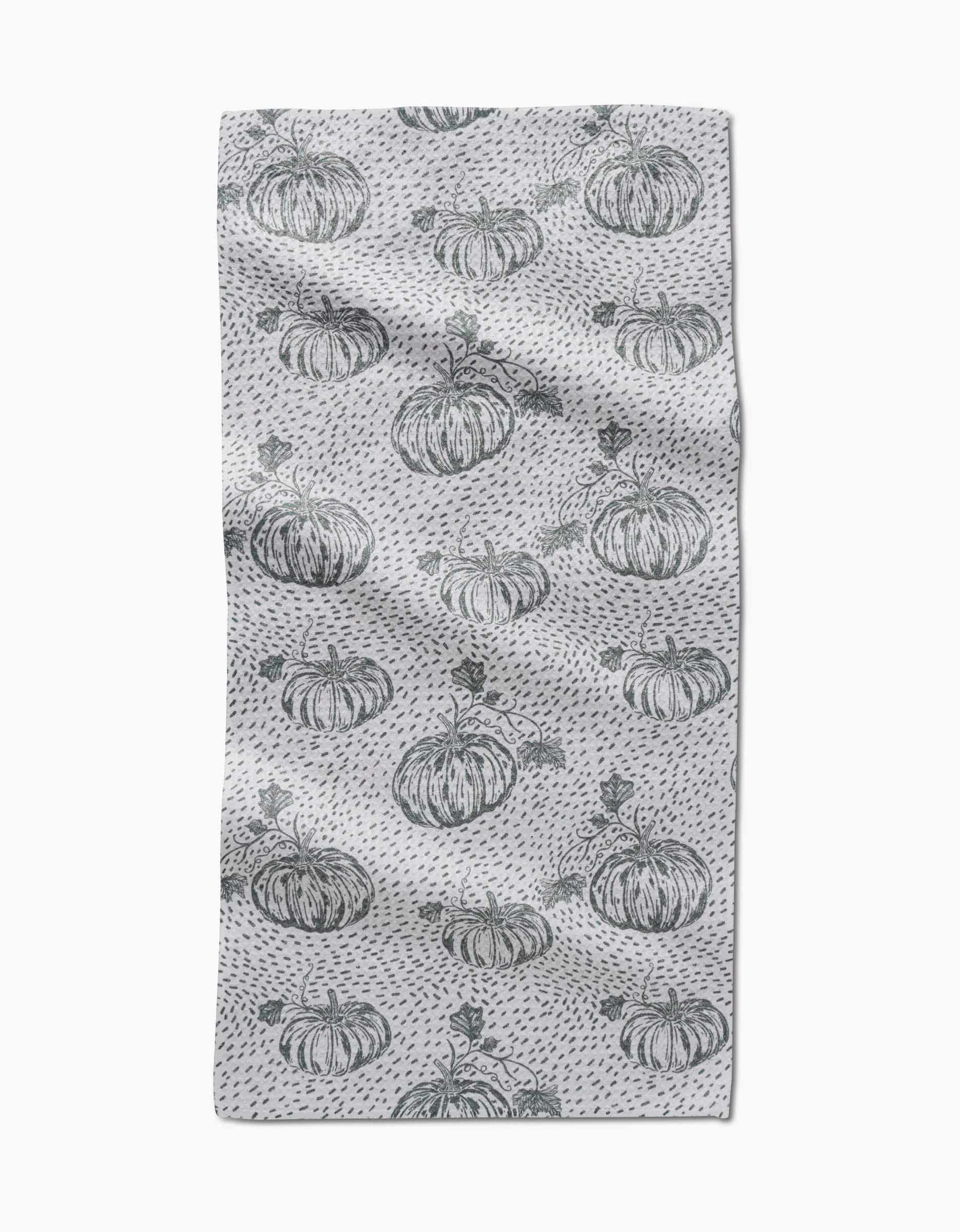 The Sage Pumpkin Field bar towel by Charlie Rowan Designs features hand-drawn pumpkins and dark gray dots evenly spaced across Geoweave fabric, creating a charming pattern on a slightly textured surface.