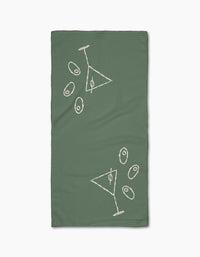 The Shaken Not Stirred bar towel by Rosa Kichline is green, rectangular, and features two white outlined martini glasses with scattered olives in a minimalist style. Made from ultra-absorbent recycled materials for eco-friendly use.