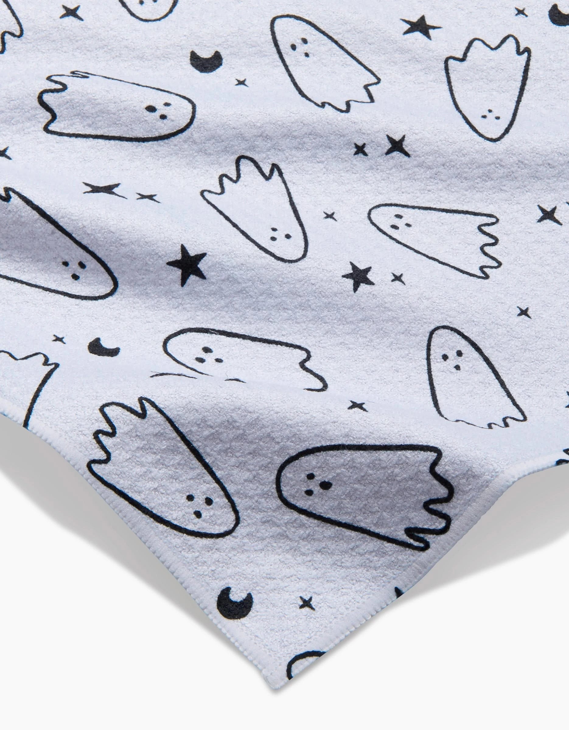 The Space Ghosts Outline towel by Hufton Studio is a light-colored, ultra-absorbent towel with playful black outlined cartoon ghosts, stars, and crescent moons patterned across the surface.