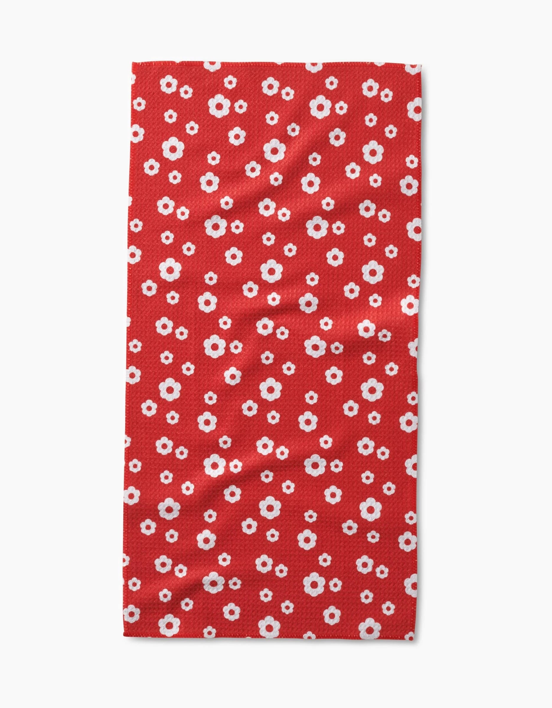 The Sunny Flowers rectangular bar towel by Danelys Sidron is made from recycled materials and features small white and pink daisy-like flowers evenly spread on a solid red background.