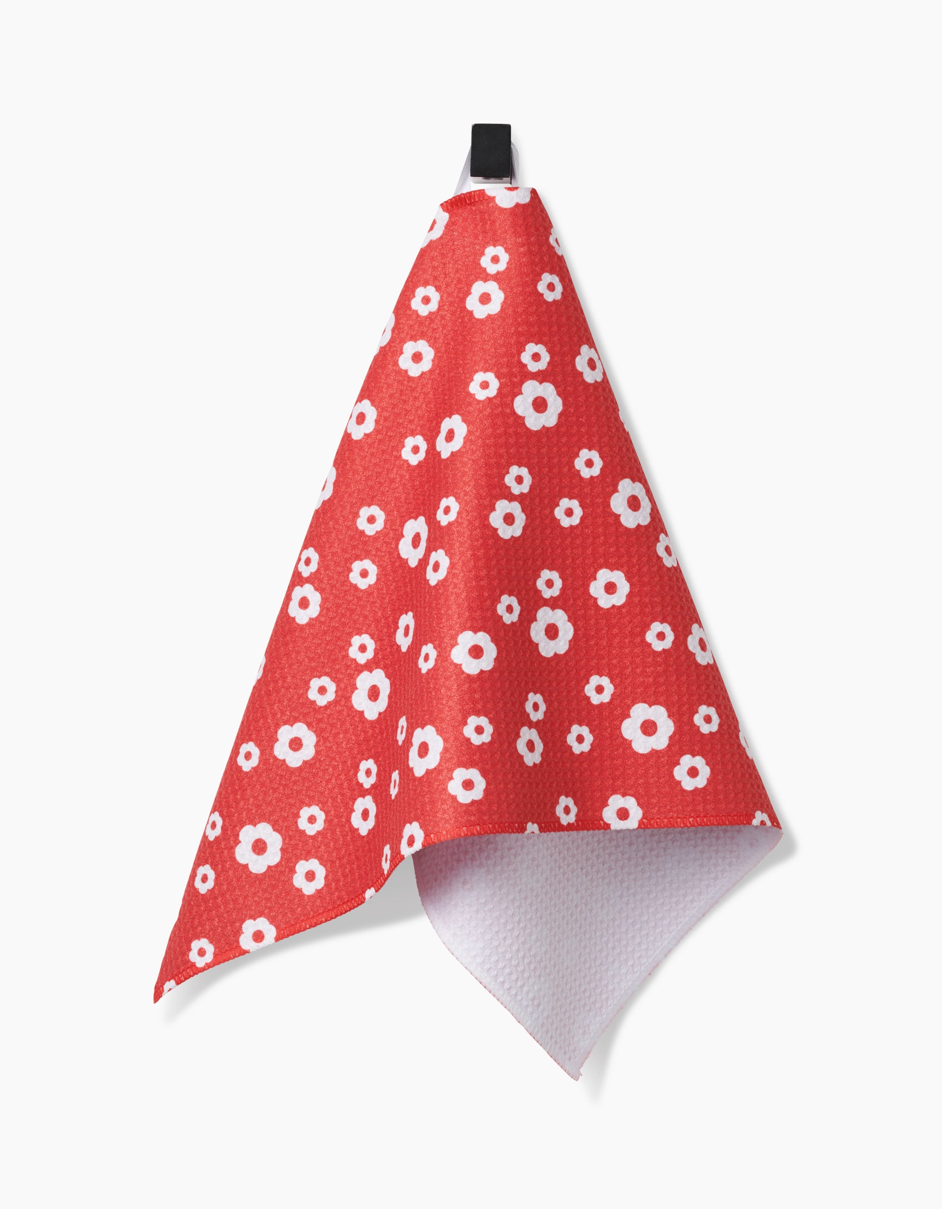 The Sunny Flowers Bar Towel by Danelys Sidron features a red background with white and pink floral patterns, hangs from a black loop, is made of Geoweave fabric with a textured front, and has a white reverse side.