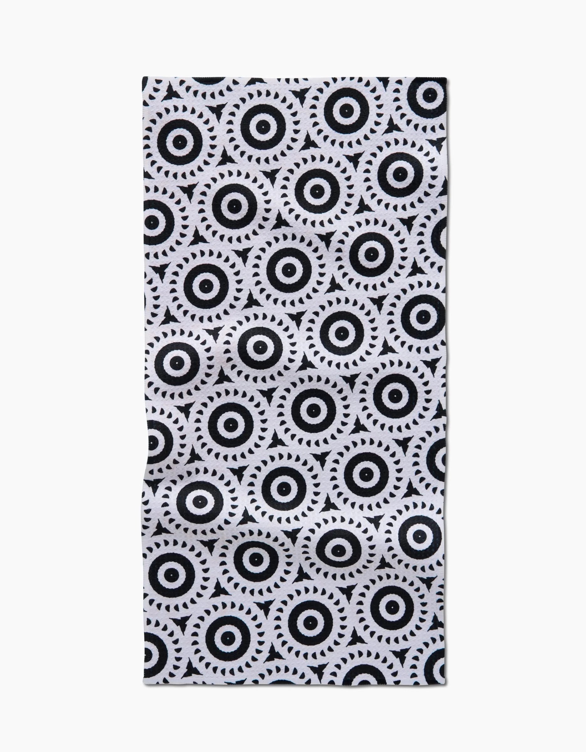 The Texas Two Step Bar Towel by Katherine Berkeley features a white Geoweave fabric with a repeating geometric motif of black concentric circles and triangles, creating an eye-like pattern.