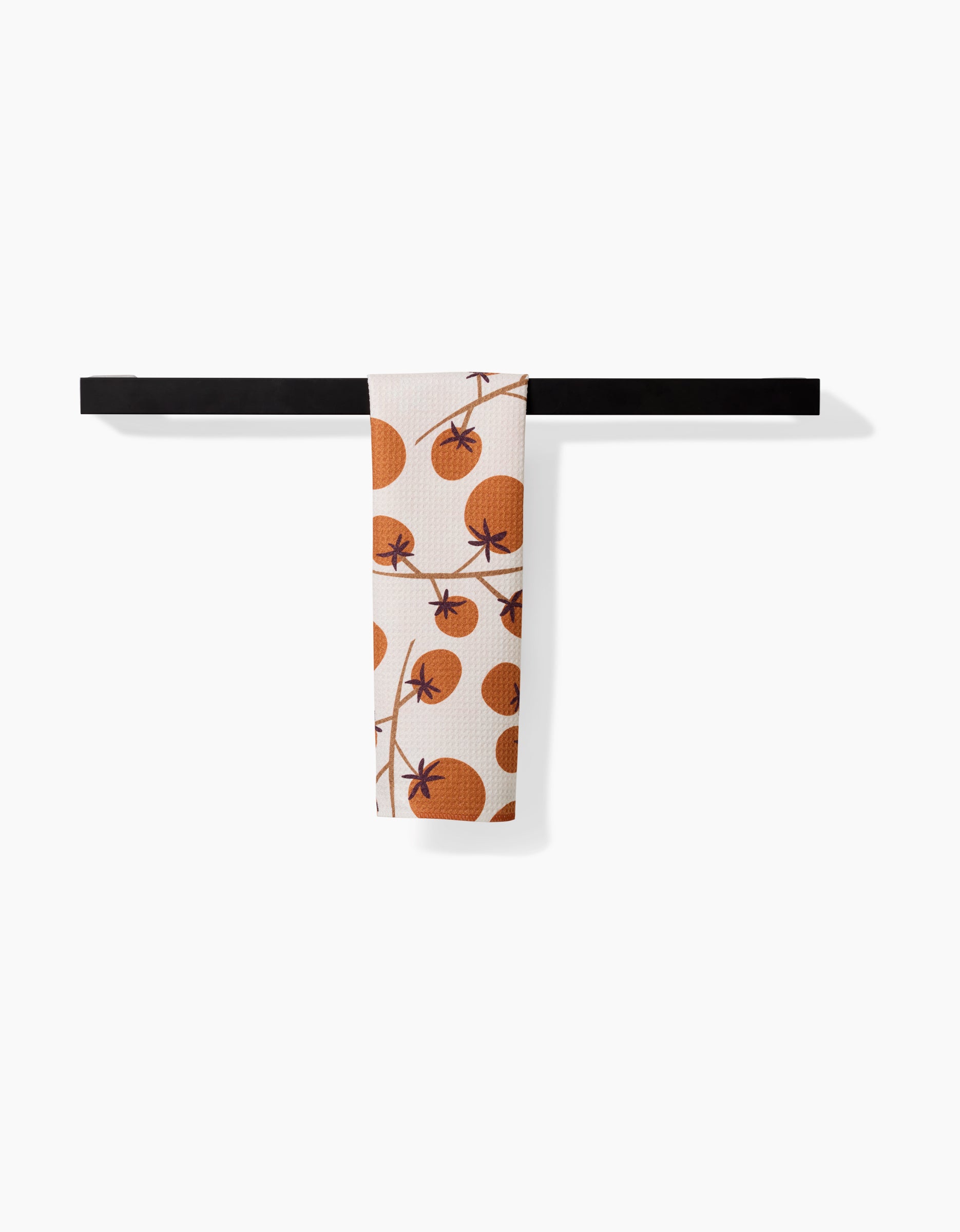 The Tomato Harvest bar towel by Lizzie Clark, featuring an orange tomato and polka dot design, hangs neatly on a black bar against a white background. Made from soft Geoweave fabric.