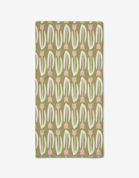 Kayla Anns Tulip Tango Bar Towel is rectangular, made from recycled materials, and features a playful modern pattern of white curved lines and pink tulip-like shapes in vertical rows on a solid green background.