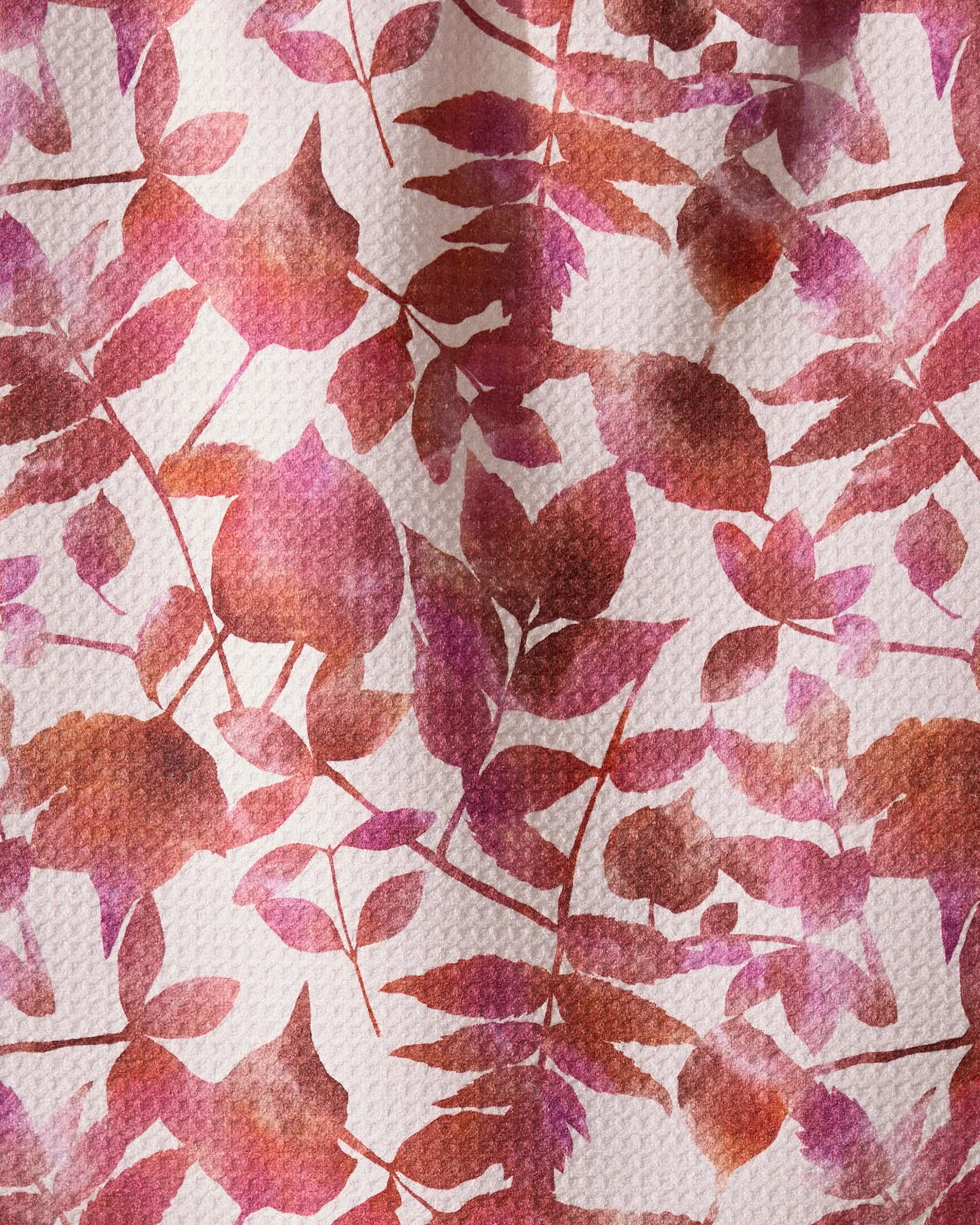 Geometrys Watercolor Dreaming towel features a soft, artistic botanical design with overlapping red, pink, and orange leaves on textured white—perfect for an ultra-absorbent addition to your kitchen.