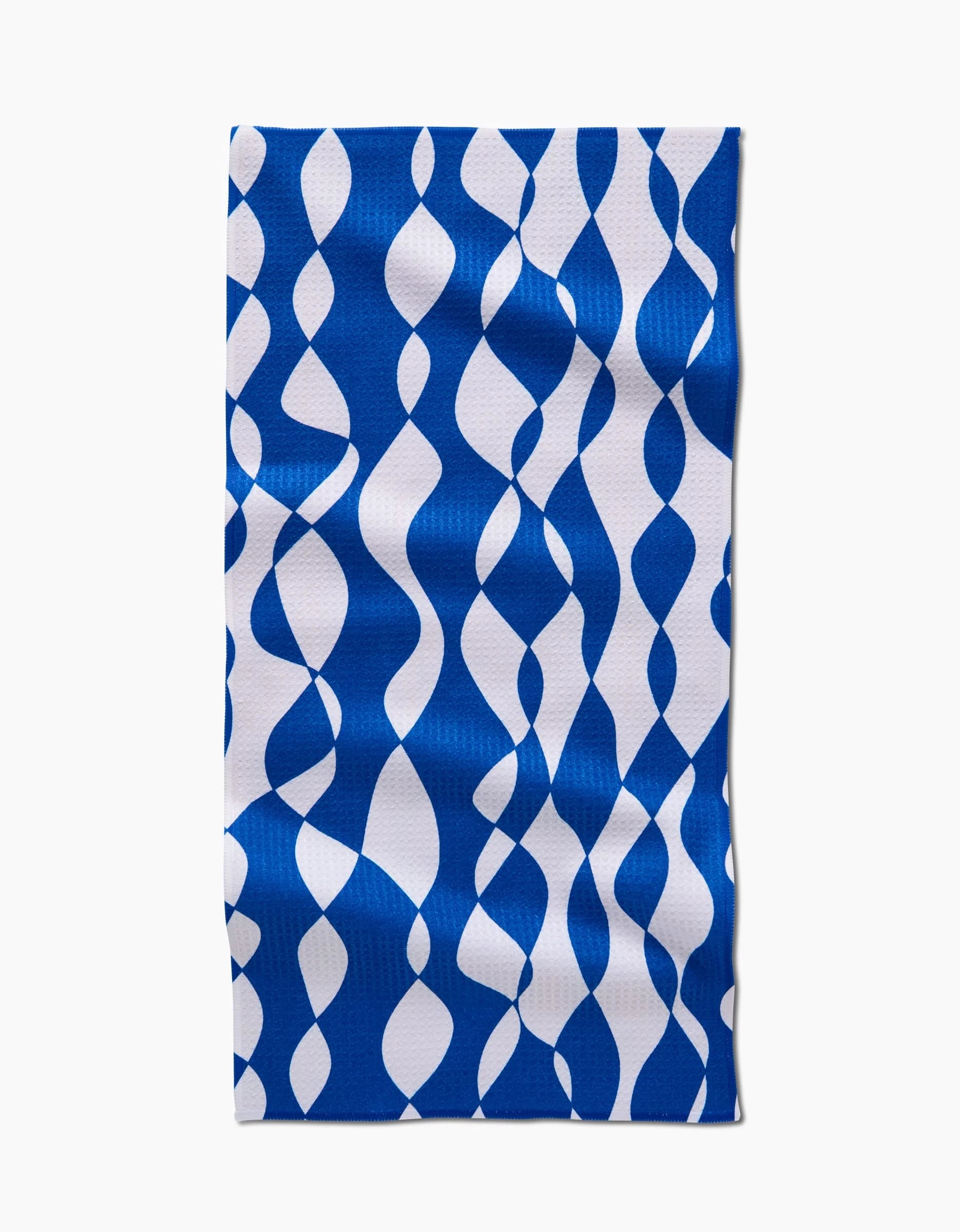The Wonky Lines rectangular bar towel by Claire Iglesias is made from Geoweave fabric and showcases a blue and white wavy, interlocking ribbon-like pattern on a white background.
