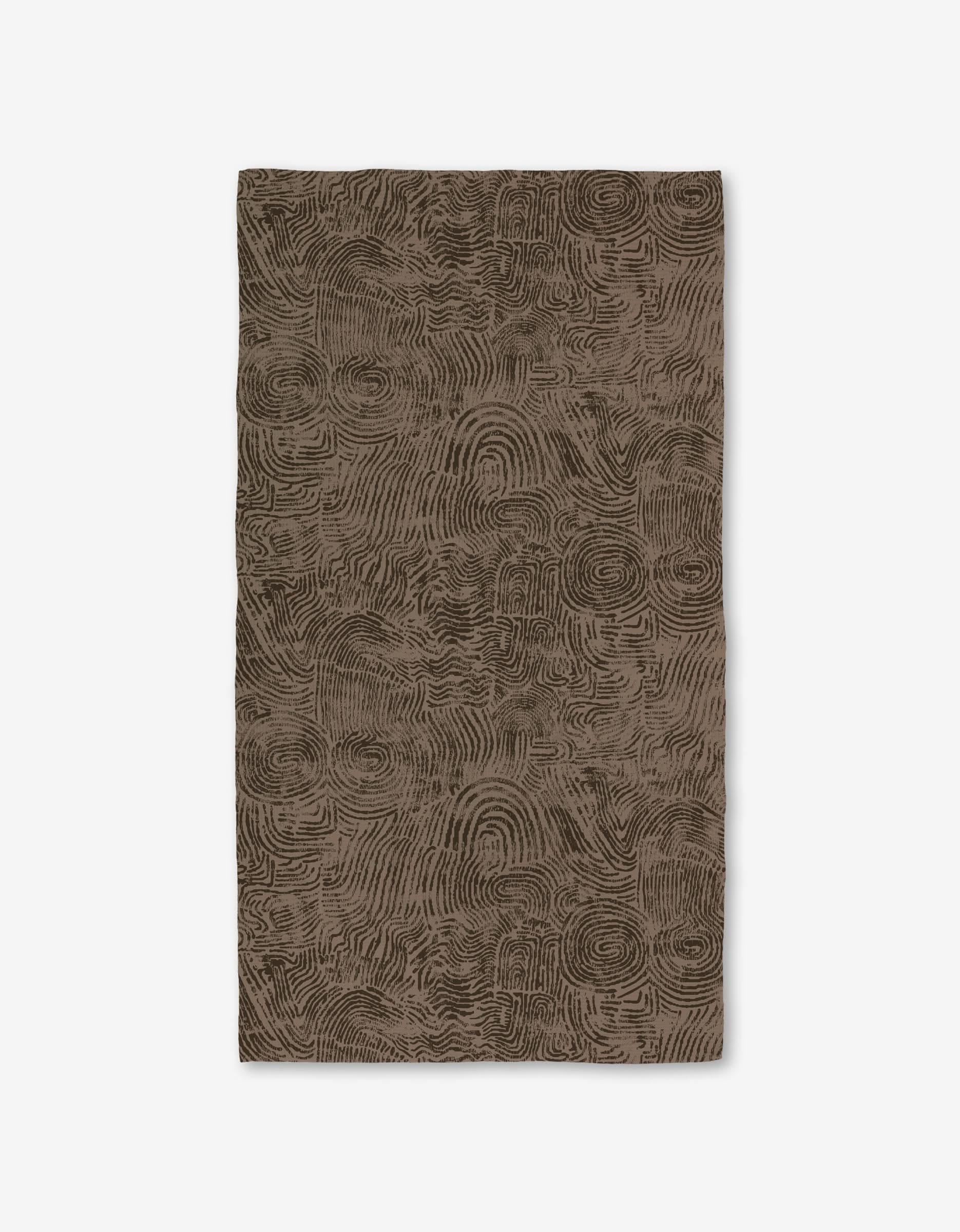 The Imprint rug by Studio Jeannot is a rectangular brown rug featuring an abstract, textured pattern of swirling lines on a white background, crafted with ultra-absorbent Geoweave technology for enhanced comfort.
