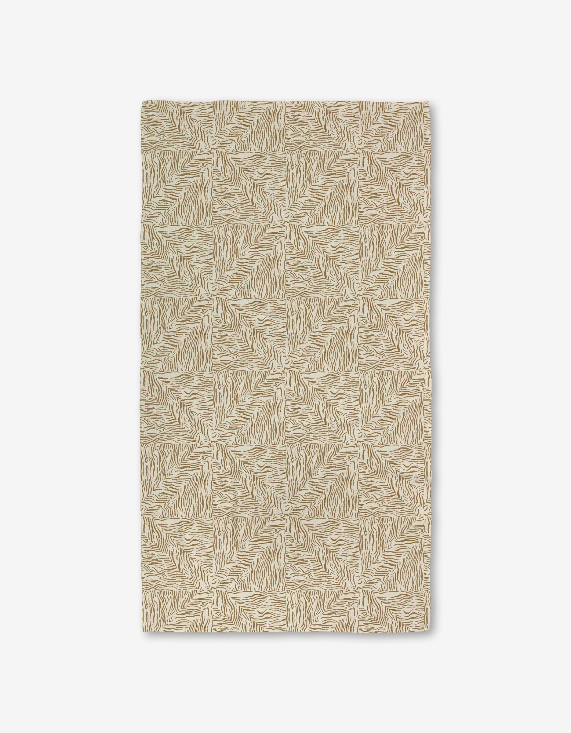 The Studio Jeannot Inlay rug is rectangular and beige with a repeating abstract geometric pattern. Made with Geoweave technology for added durability, it has a textured look and is shown flat on a white background.