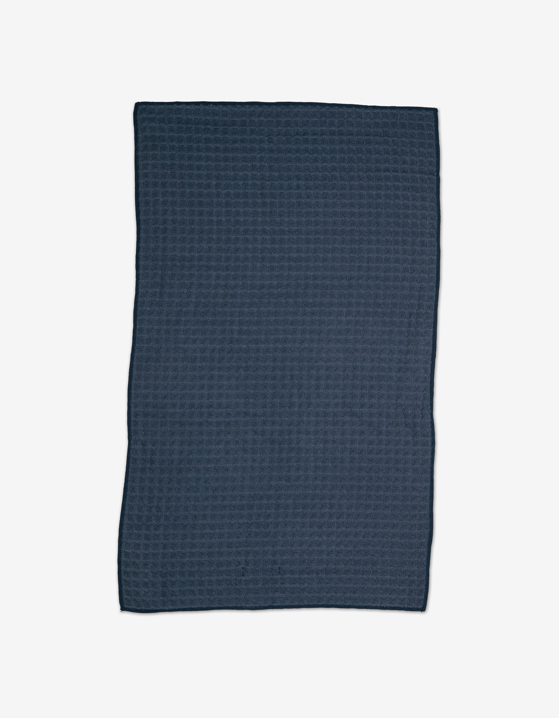 The GEOMETRY Midnight Blue Waffle Bath Towel features a dark blue, rectangular design with a subtle textured pattern—ideal for those who value eco-friendly towels and modern elegance.