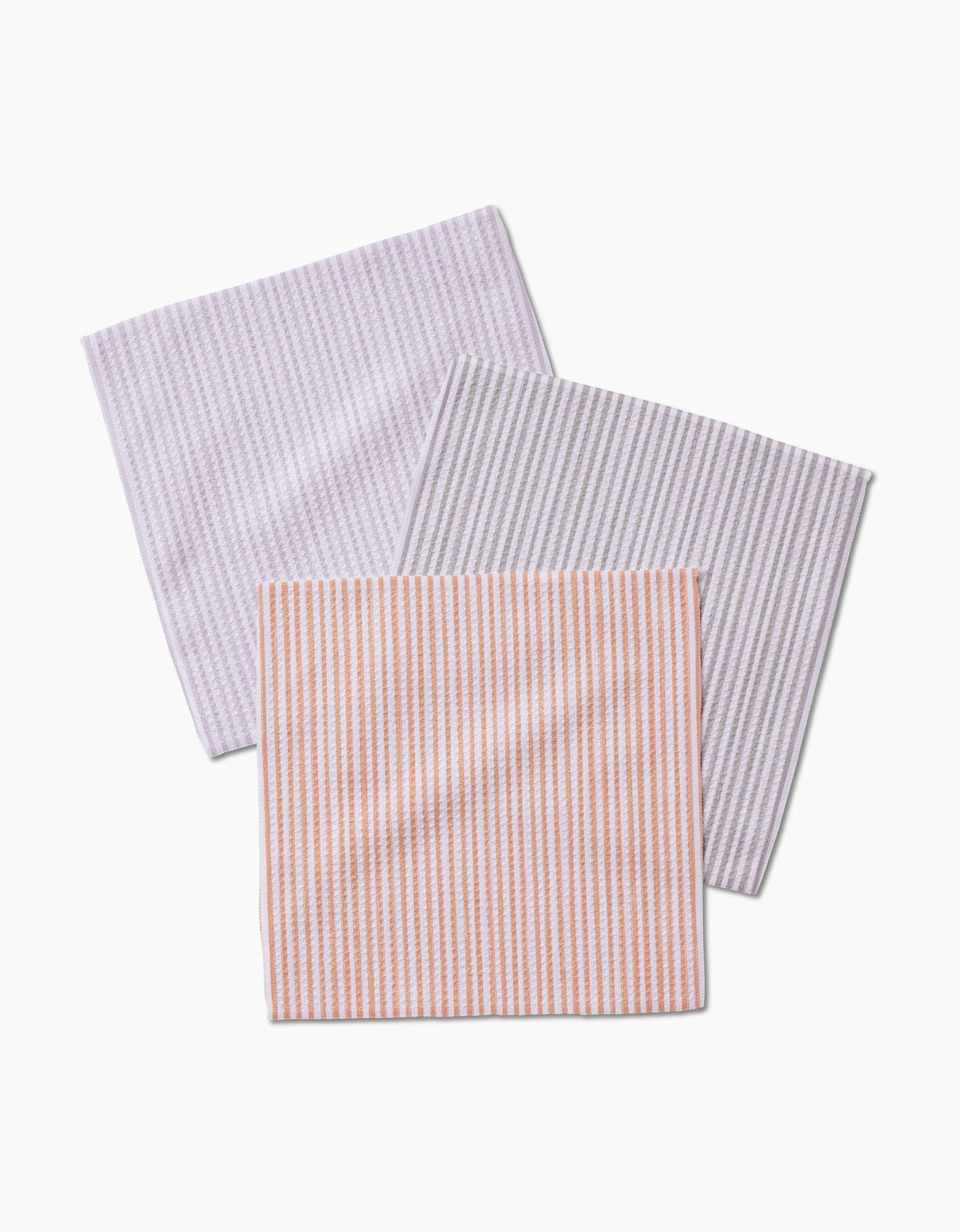 Three overlapping À La Carte dishcloths by Kailee Wright, made from recycled Geoweave fabric in pastel pink, gray, and orange with thin vertical stripes, set on a white background.