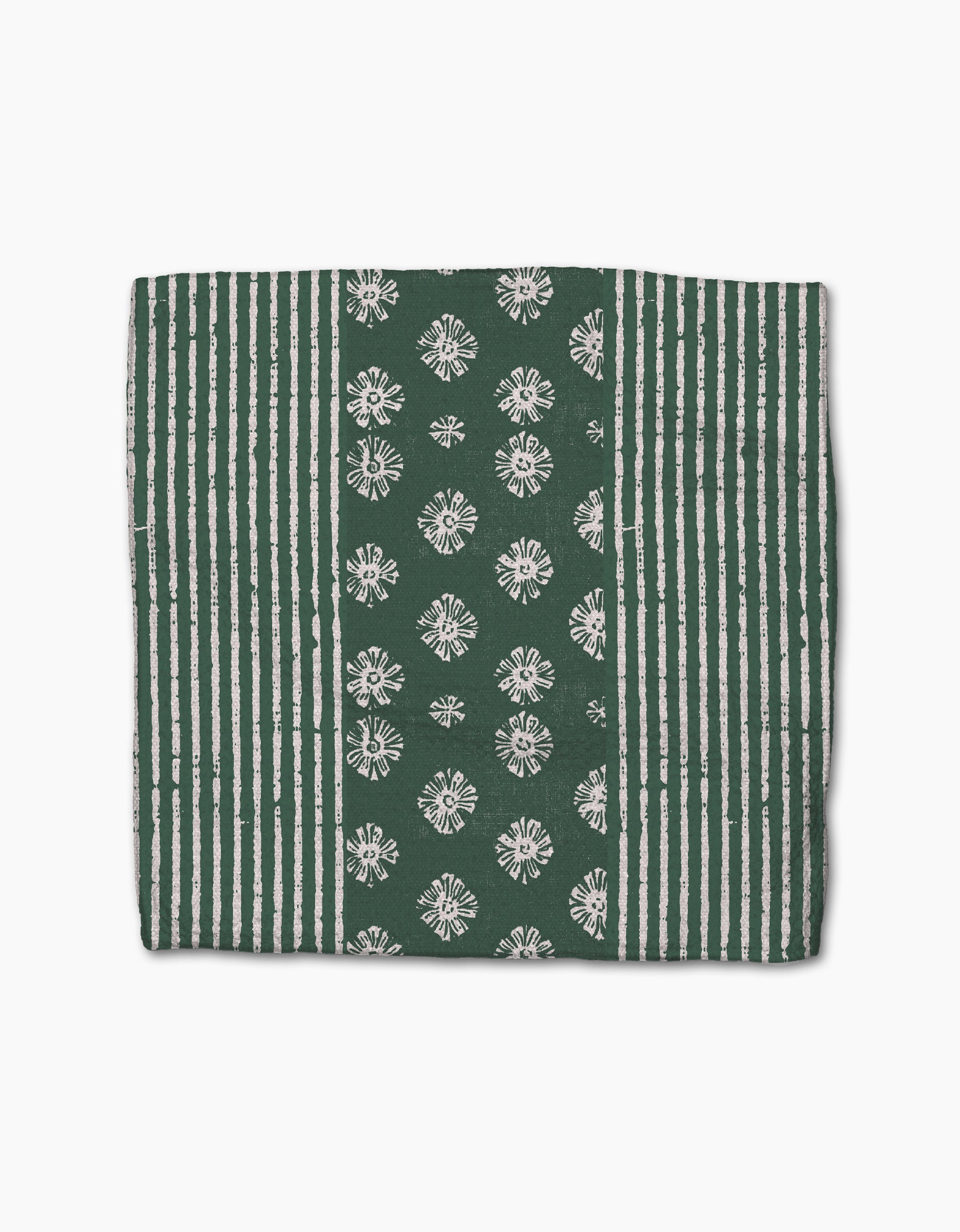 The Arbusto placemat by Geometry is rectangular, green, and made from recycled materials. It features vertical white stripes on the sides and a central band with white flower patterns for a simple, symmetrical look.