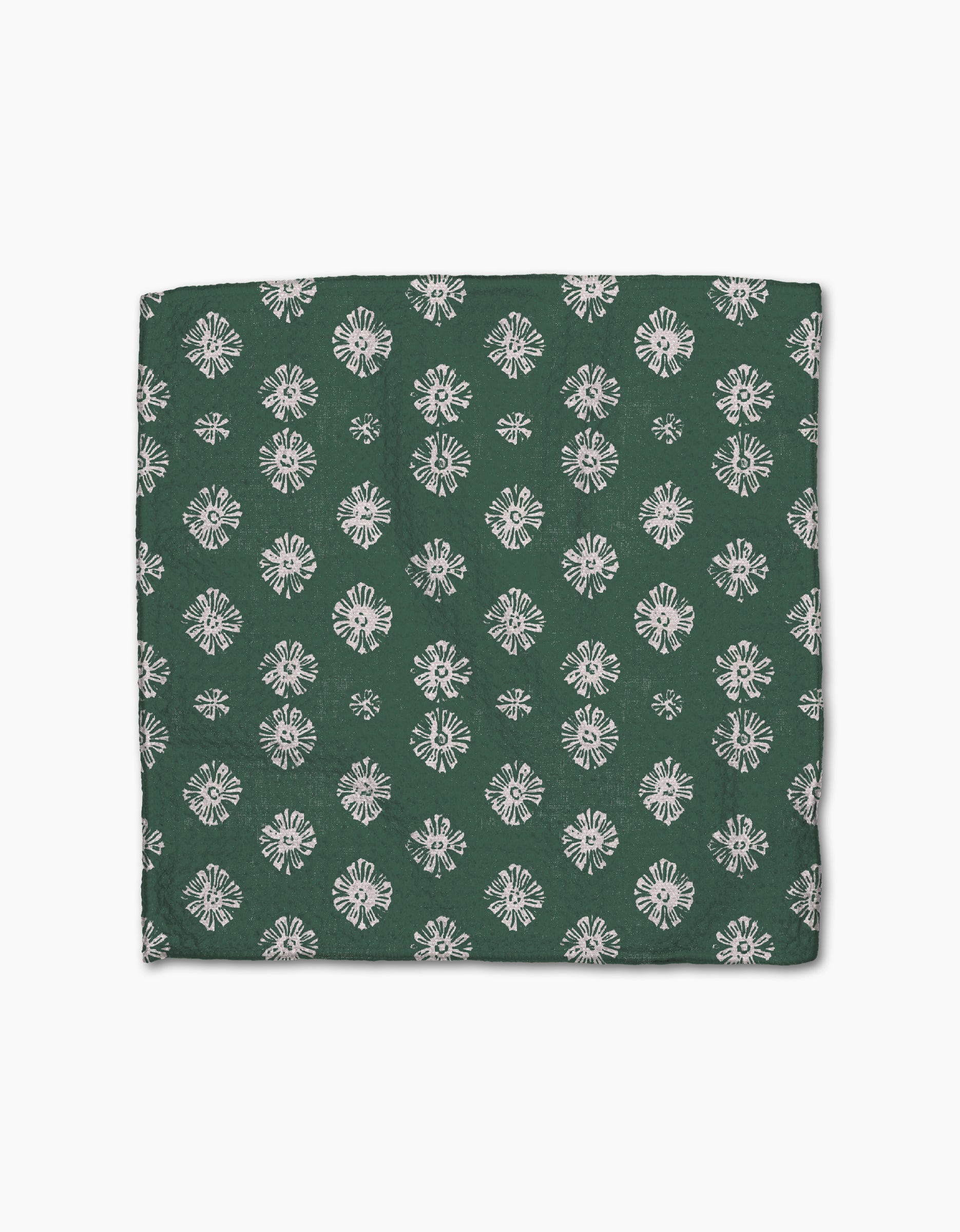 The Geometry Arbusto dishcloth, crafted from Geoweave fabric, features a folded green design with a repeating white floral pattern and is displayed on a plain white background.