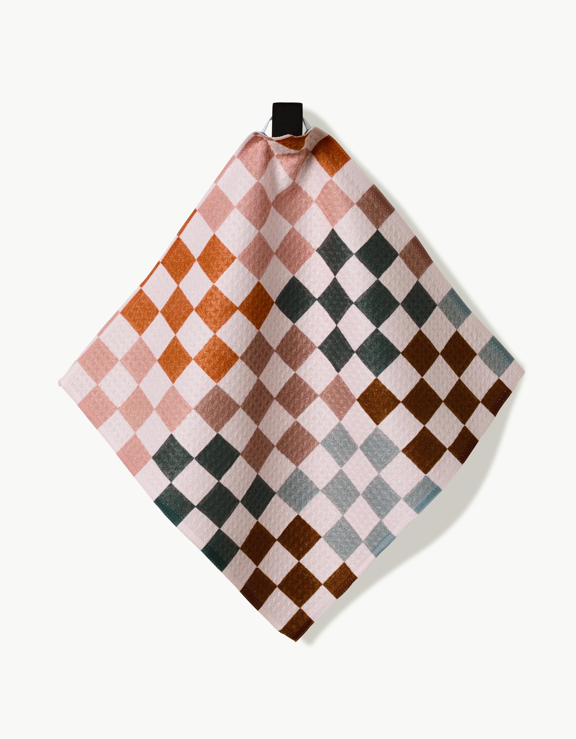 The GEOMETRY Autumn Checkers dishcloth features a square shape with pink, brown, green, and gray checkered pattern. Made from durable Geoweave fabric, it hangs from a black loop against a white background for superior cleaning.