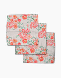 Three folded Elena Fay Blush Florals kitchen towels made from Geoweave fabric, each with a vibrant pink, orange, and coral floral print with green leaves. The dishcloths are stacked in an overlapping, charming display.