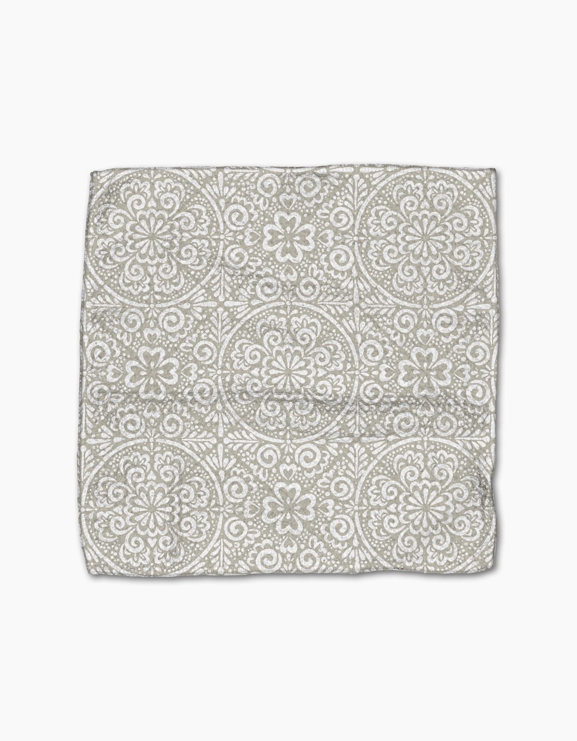 The Boho Medallion cloth napkin by Kris Ruff is crafted from Geoweave fabric and showcases a gray and white medallion pattern on a white background, displayed flat against a white surface.