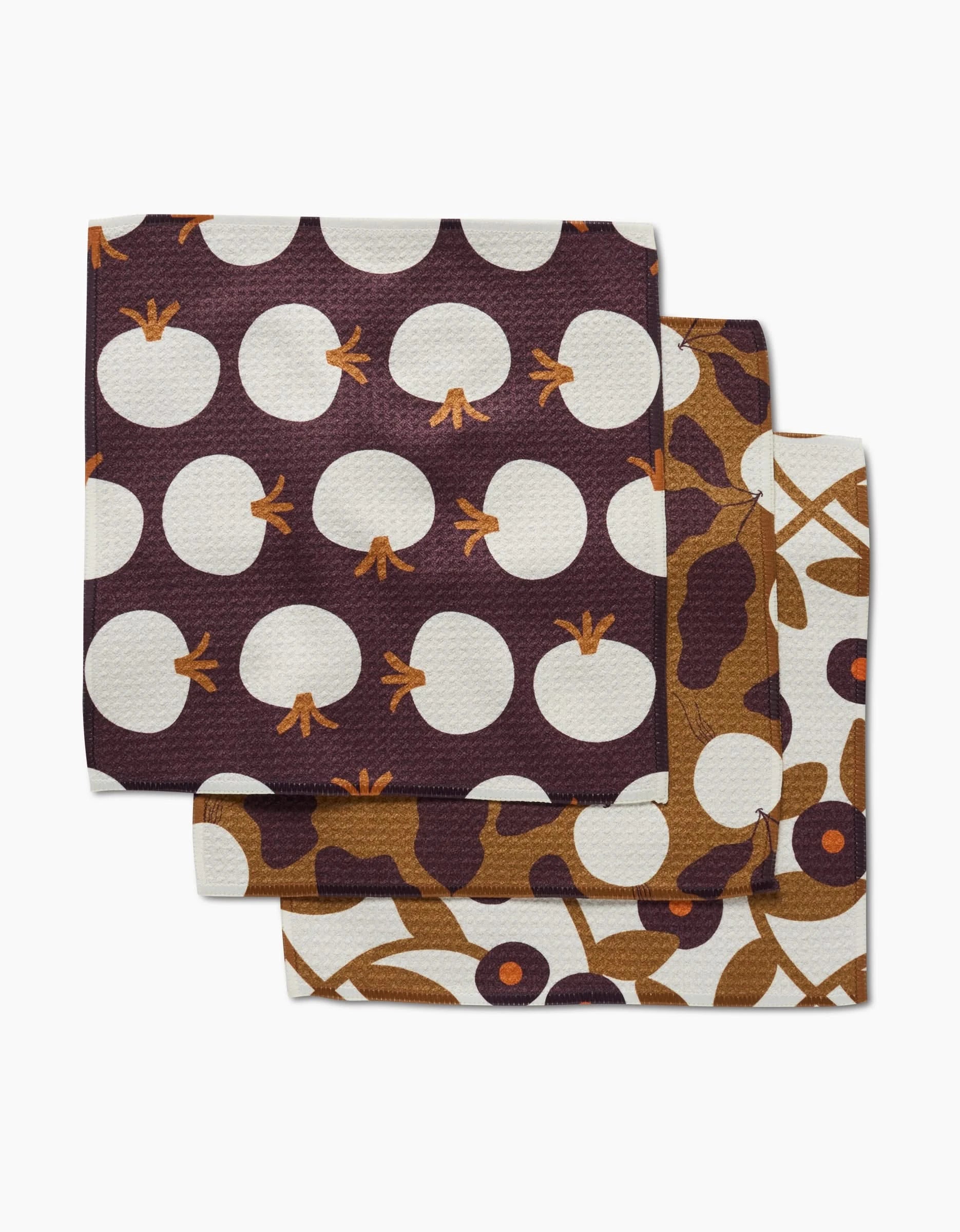 The Lizzie Clark Bold Fall set includes three square napkins in brown, white, and mustard yellow with abstract fruit and floral prints—an eco-friendly, stylish update for your table.