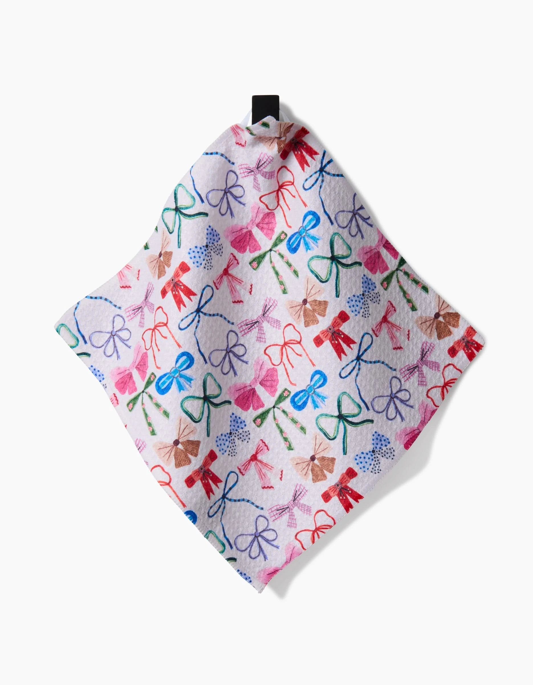 The Bows dishcloth by Daria Solak features a vibrant hand-drawn bow pattern in red, blue, green, and purple on white. Made with Geoweave Technology, it hangs from a black loop and is shown on a white background.