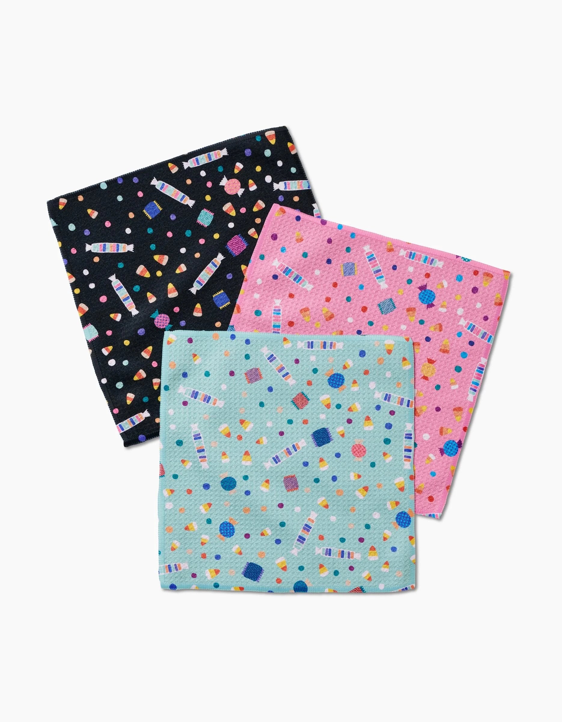 The Candy Rush dishcloths by Rebecca Bobko feature three overlapping Geoweave fabric squares—black, pink, and light blue—with vibrant geometric, candy-inspired patterns. These eco-friendly cloths bring playful style to your kitchen.