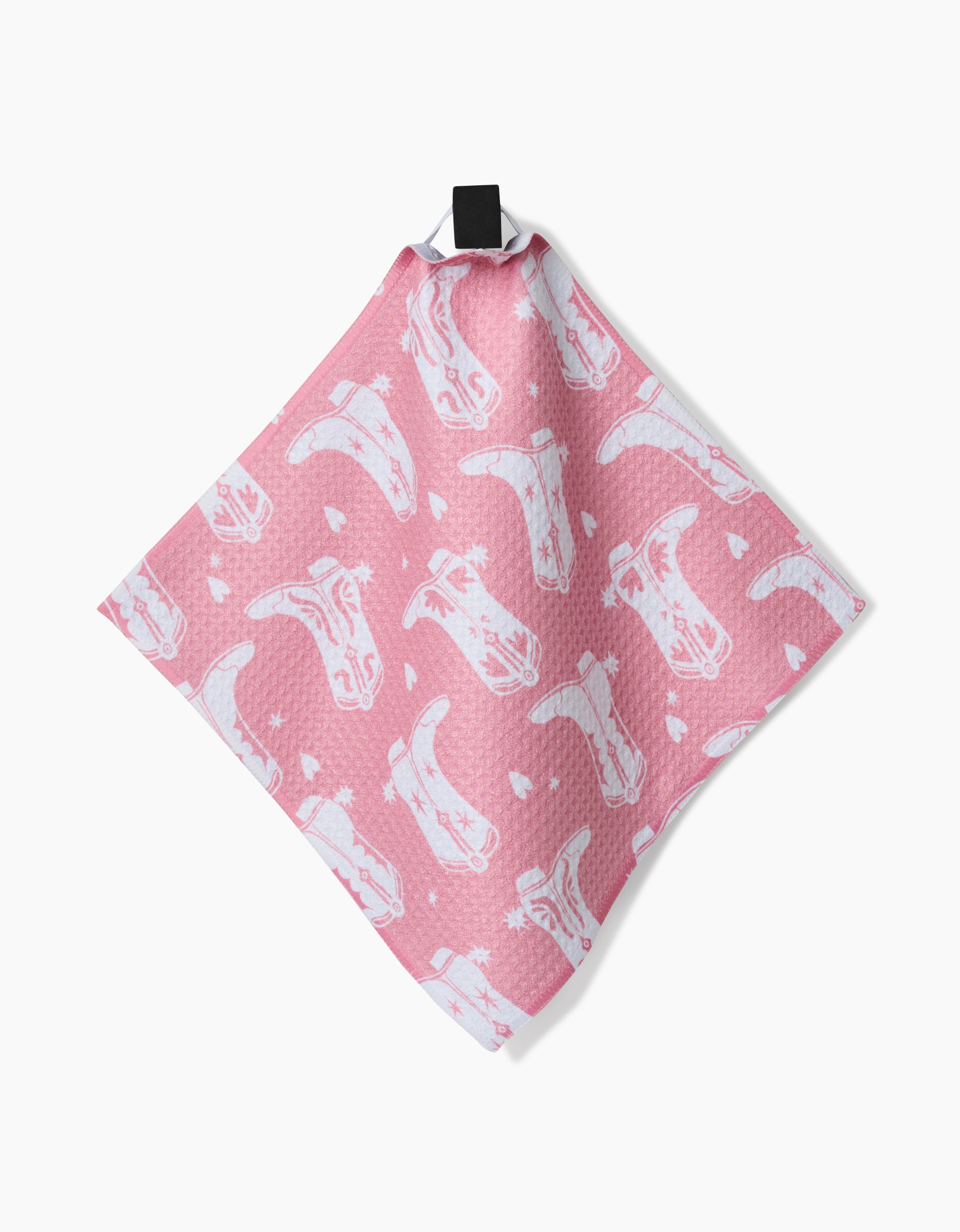 The Chic Lucky Boots pink dishcloth, crafted from recycled materials, showcases a white cartoon cowboy hats and boots pattern and hangs by a black loop against a white background.