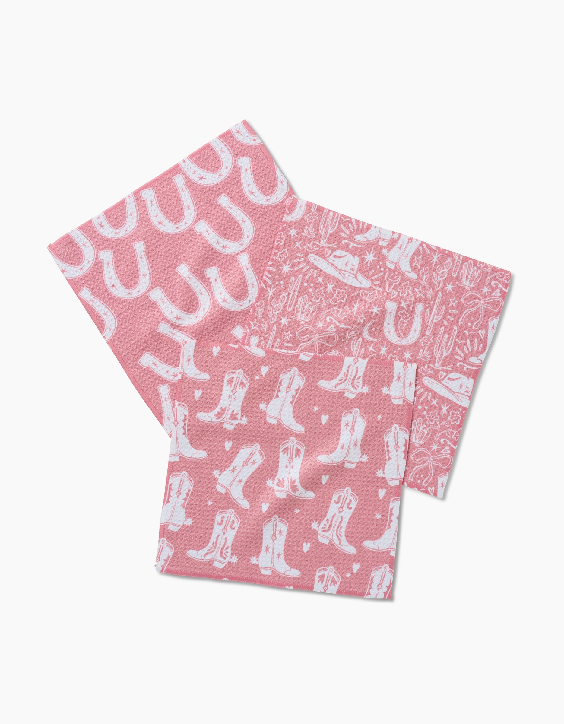 Chic Lucky Boots: Set of three pink recycled dishcloths with white Western prints—horseshoes, cowboy boots, and desert designs including cacti, boots, horseshoes, and an alien spaceship.