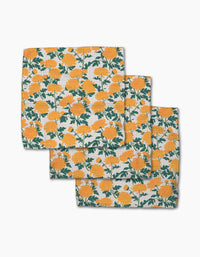 Three folded cloth napkins from the Chrysanthemum collection by Vaishali Design Studio are stacked, each made with Geoweave fabric and adorned with a pattern of bright yellow flowers and green leaves on a white background.