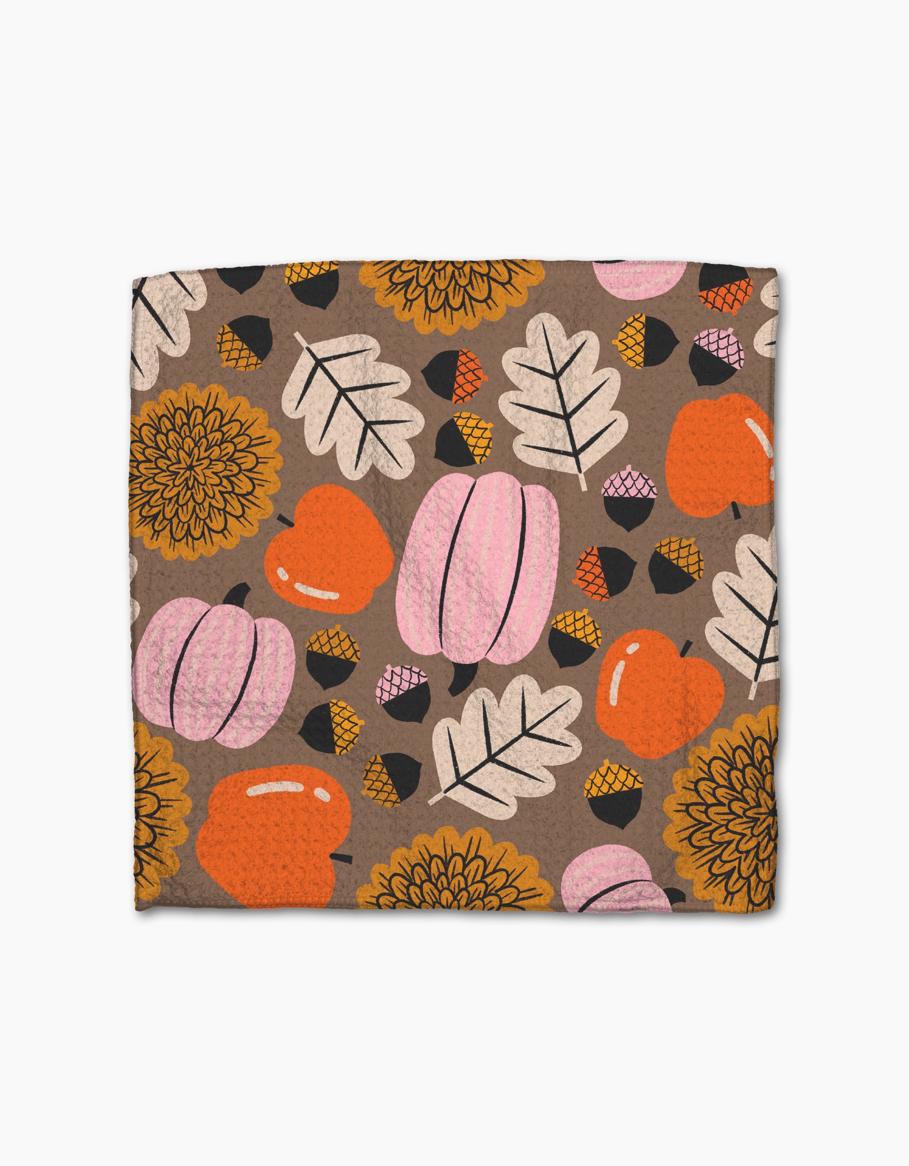 The Crisp and Cozy dish towel by Megan Roy is a square, absorbent towel featuring a fall-themed pattern of pink pumpkins, orange apples, beige leaves, yellow flowers, and small acorns on a brown background.