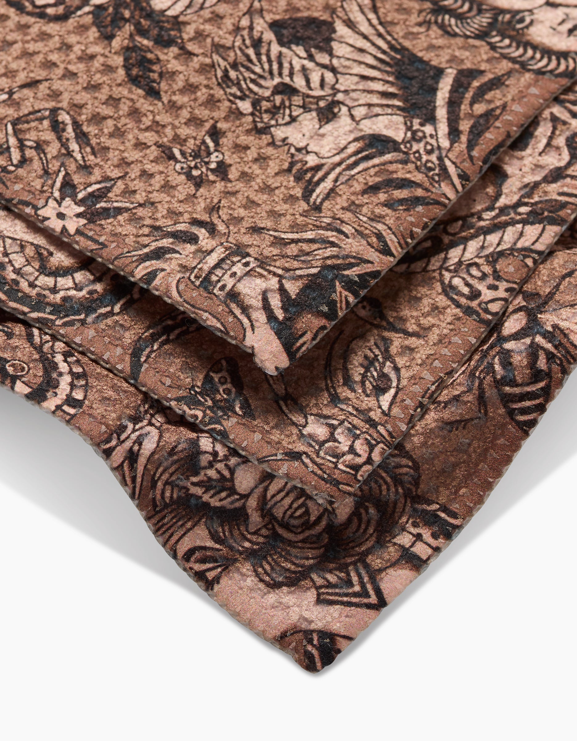 Close-up of three Flash Geoweave fabric squares by Cole Strem, in brown with intricate black floral and abstract patterns, made from recycled materials and overlapping on a white surface.