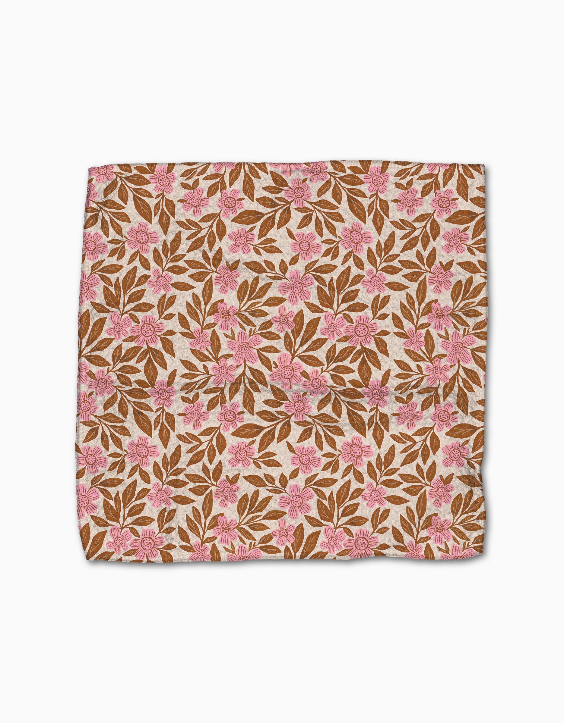Lisa Nelson’s Floral Meadow dishcloth, crafted from recycled materials, features brown leaves and pink flowers on a light beige background for a stylish, sustainable touch. Shown laid flat on a white surface.