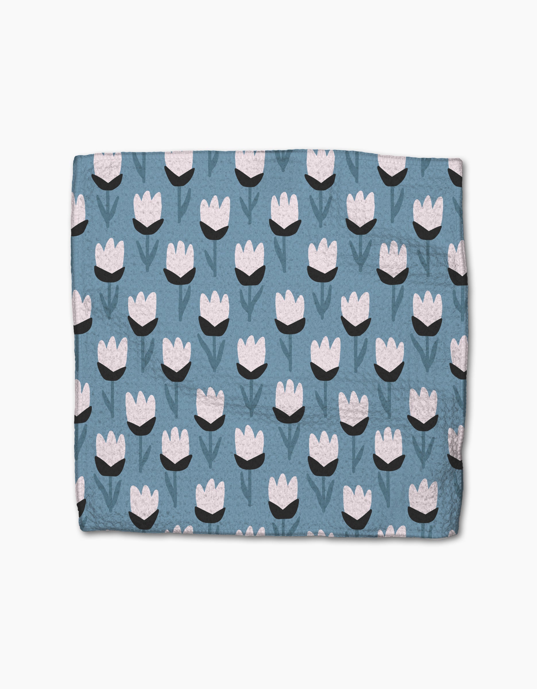 The Forest Findings blanket by Anette Heiberg is blue with a repeating tulip-inspired flower pattern in white and black, featuring green stems and leaves, crafted from recycled materials.