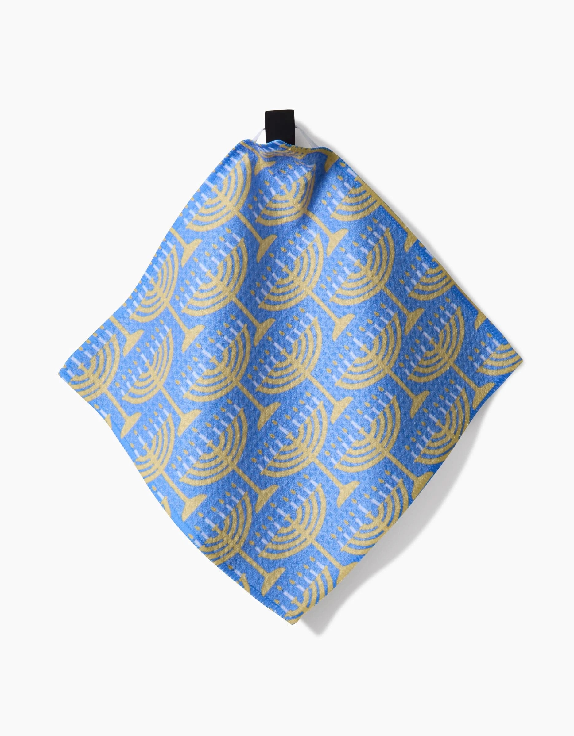 The Mindfulnice Hanukkah Lights napkin is made of blue Geoweave fabric and features a repeating yellow menorah pattern, displayed on a white background.