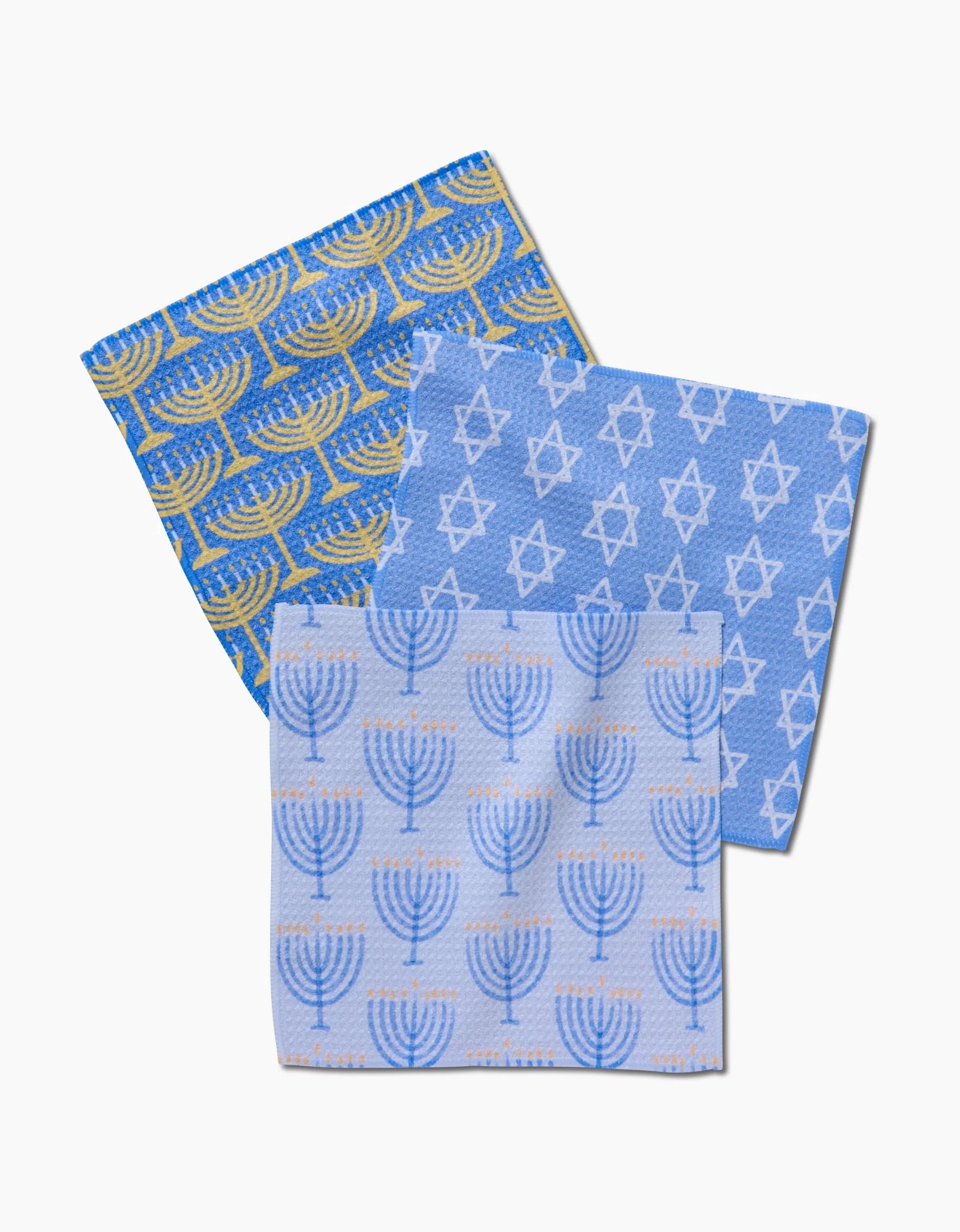 The Hanukkah Lights dishcloth set by Mindfulnice features three blue kitchen tea towels with festive menorah and Star of David designs, made from durable Geoweave fabric—perfect for brightening your holiday kitchen.