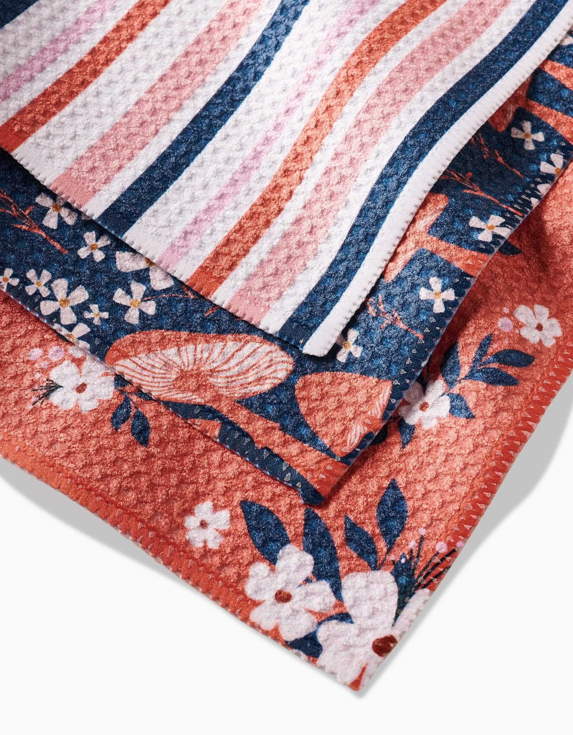 A close-up of three Harvest Season dishcloths by Charlie Rowan Designs, featuring Geoweave fabric and colorful patterns: pink/blue stripes, blue/orange florals, and orange/white flowers with leaves.