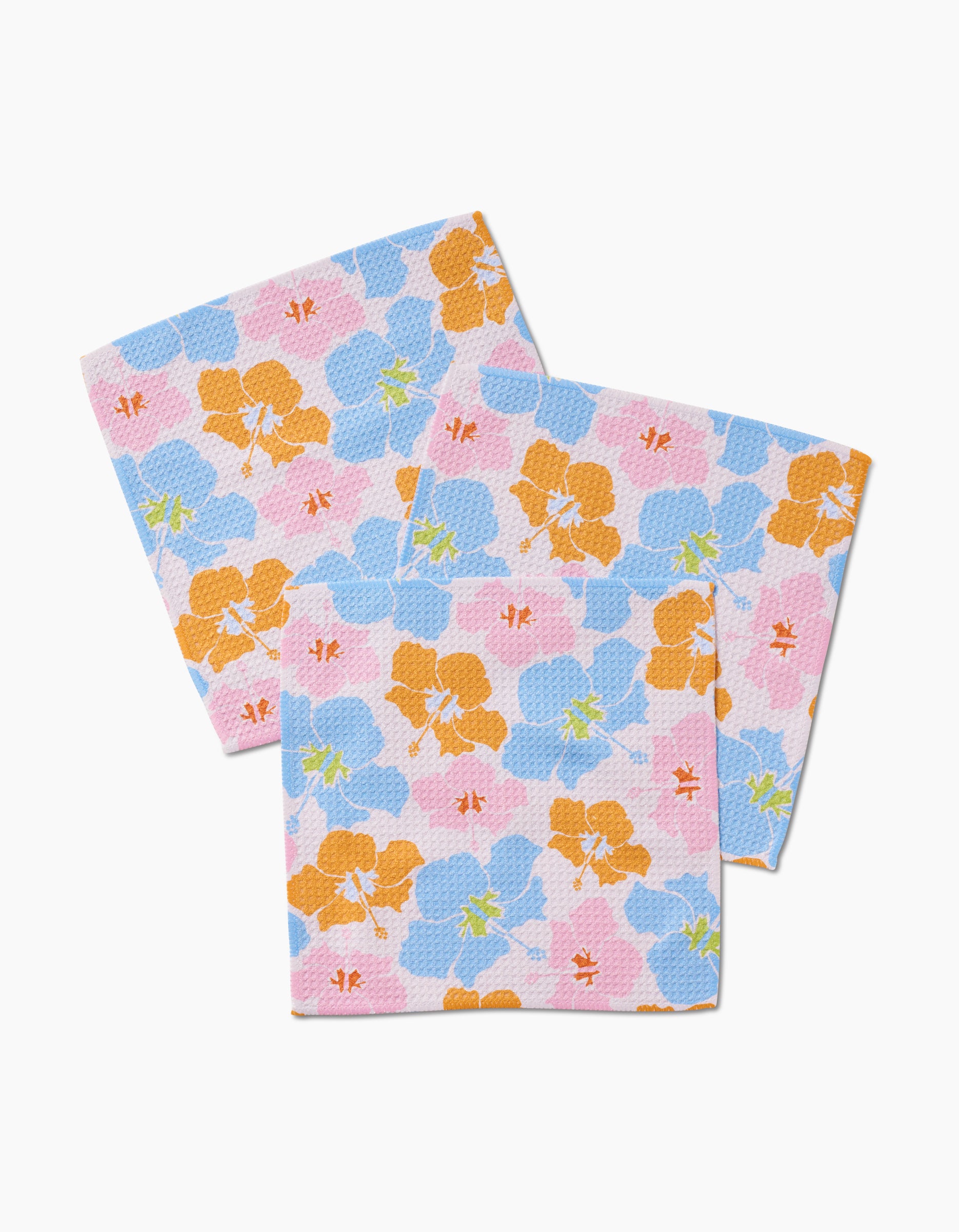 Three reusable GEOMETRY Hula Hues dishcloths, made from Geoweave fabric, display an overlapping floral pattern with orange, blue, pink flowers and red, green accents on a white background.