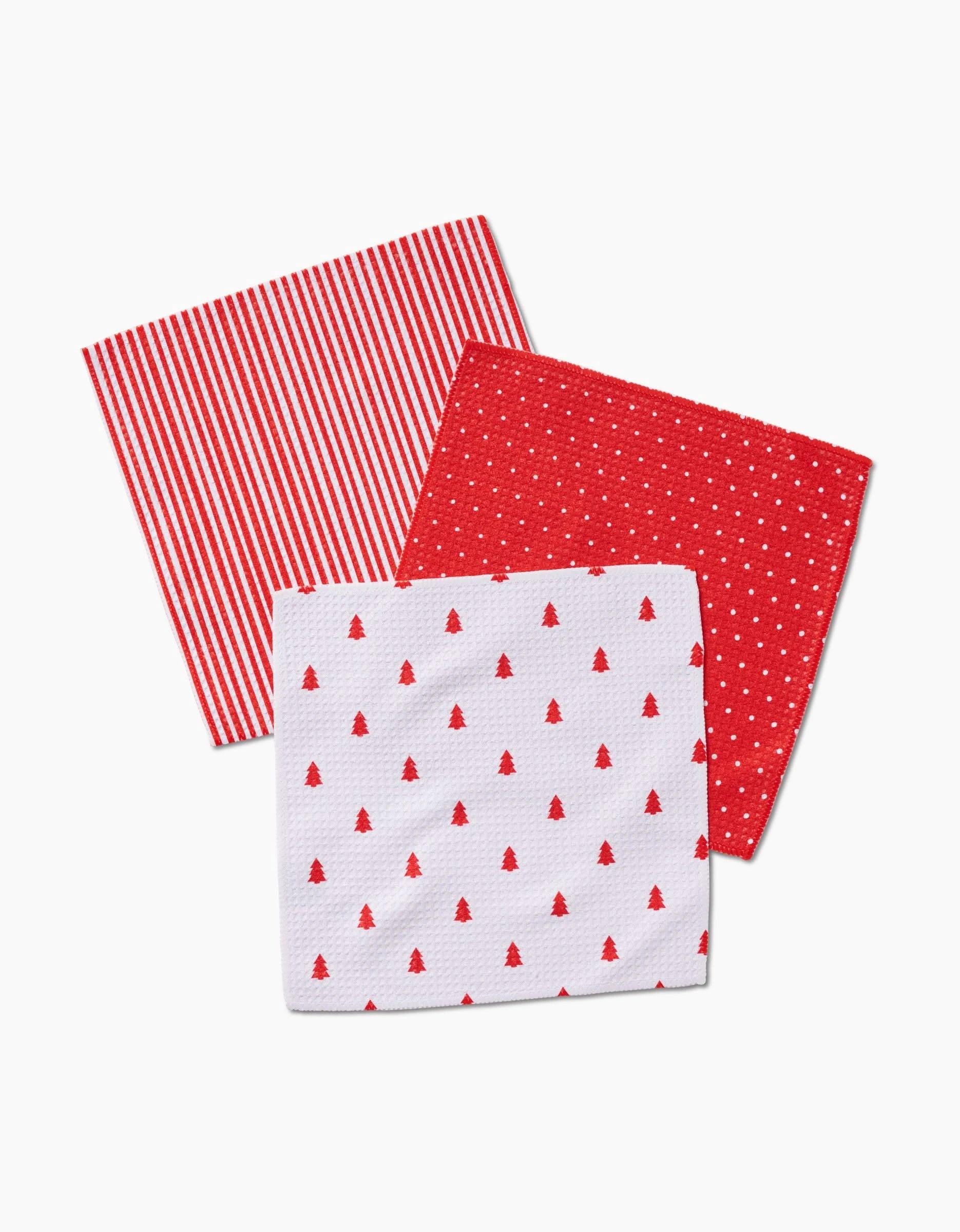 Three Kailee Wright Jolly cloth napkins made from super-absorbent Geoweave fabric—one with red and white stripes, one with red and white polka dots, and one white with red Christmas tree patterns—overlap on a white background.