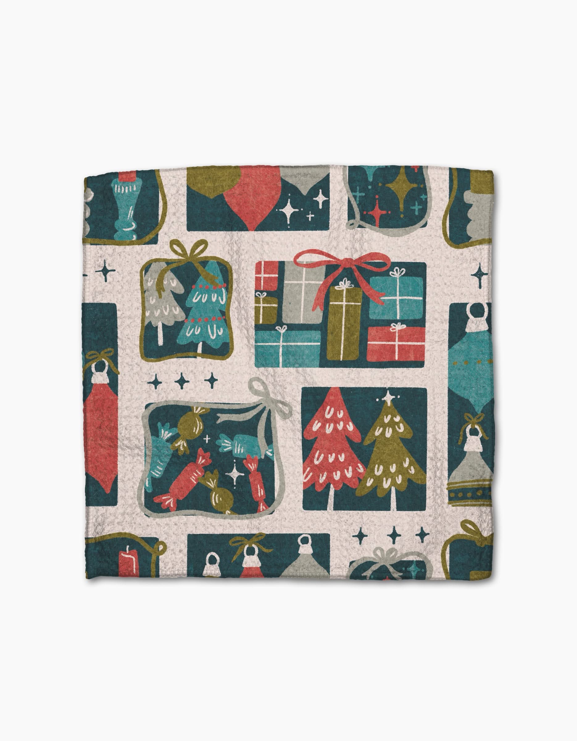 The Little Village dishcloth by Amy MacCready features a festive holiday pattern with Christmas trees, gifts, ornaments, stockings, and stars in muted red, green, blue, and beige on textured Geoweave fabric.