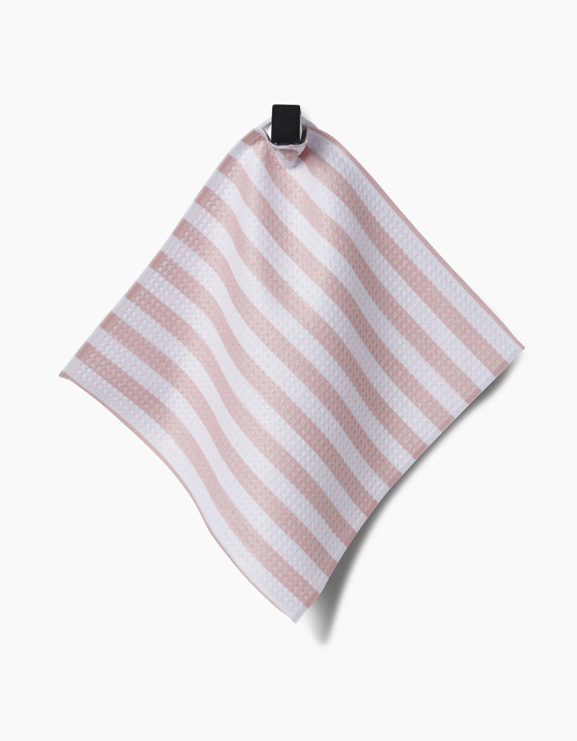 The Kailee Wright Mama towel, featuring pink and white stripes and made from recycled materials, hangs from a black hook against a plain white background.