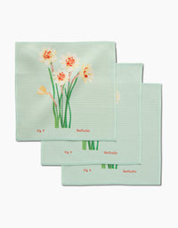 Set of three light green March Daffodils Geoweave cloth napkins by Linda Fox, each with daffodil illustrations and the words “Fig 3” and “Daffodils” in red. Made from recycled materials.