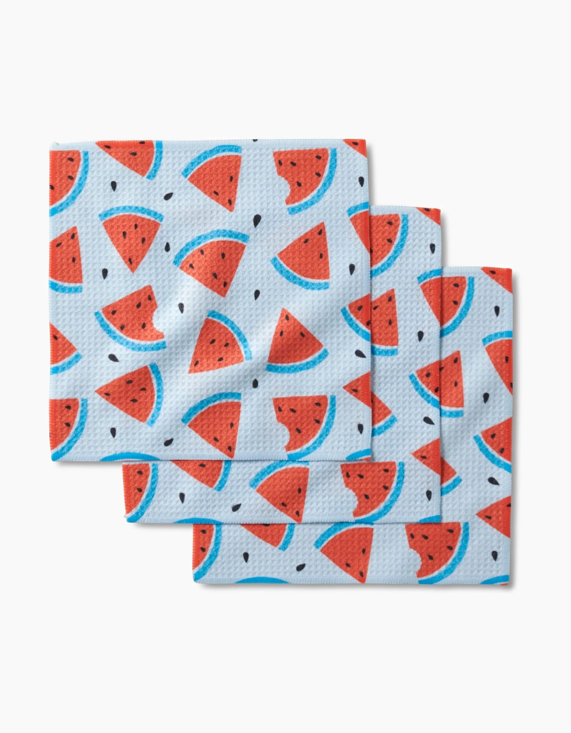 Sara Maris Melon Mingle features three recycled dishcloths with a repeating watermelon slice and seed pattern on a light blue background, stacked in a slightly overlapping arrangement.