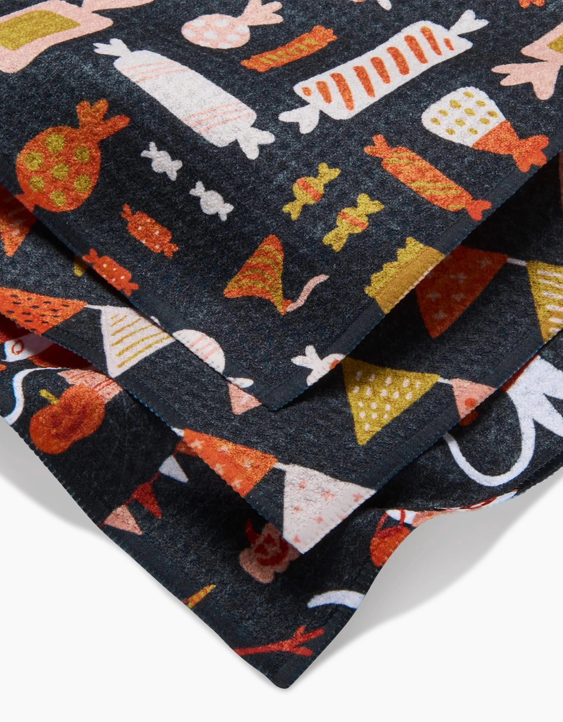 The Morticia Edwina And Morrigan dishcloth set by Amy MacCready adds a whimsical, eco-friendly touch to your kitchen with playful red, yellow, orange, and white illustrations of sausages, cheese, fish, and fruits on dark recycled fabric.