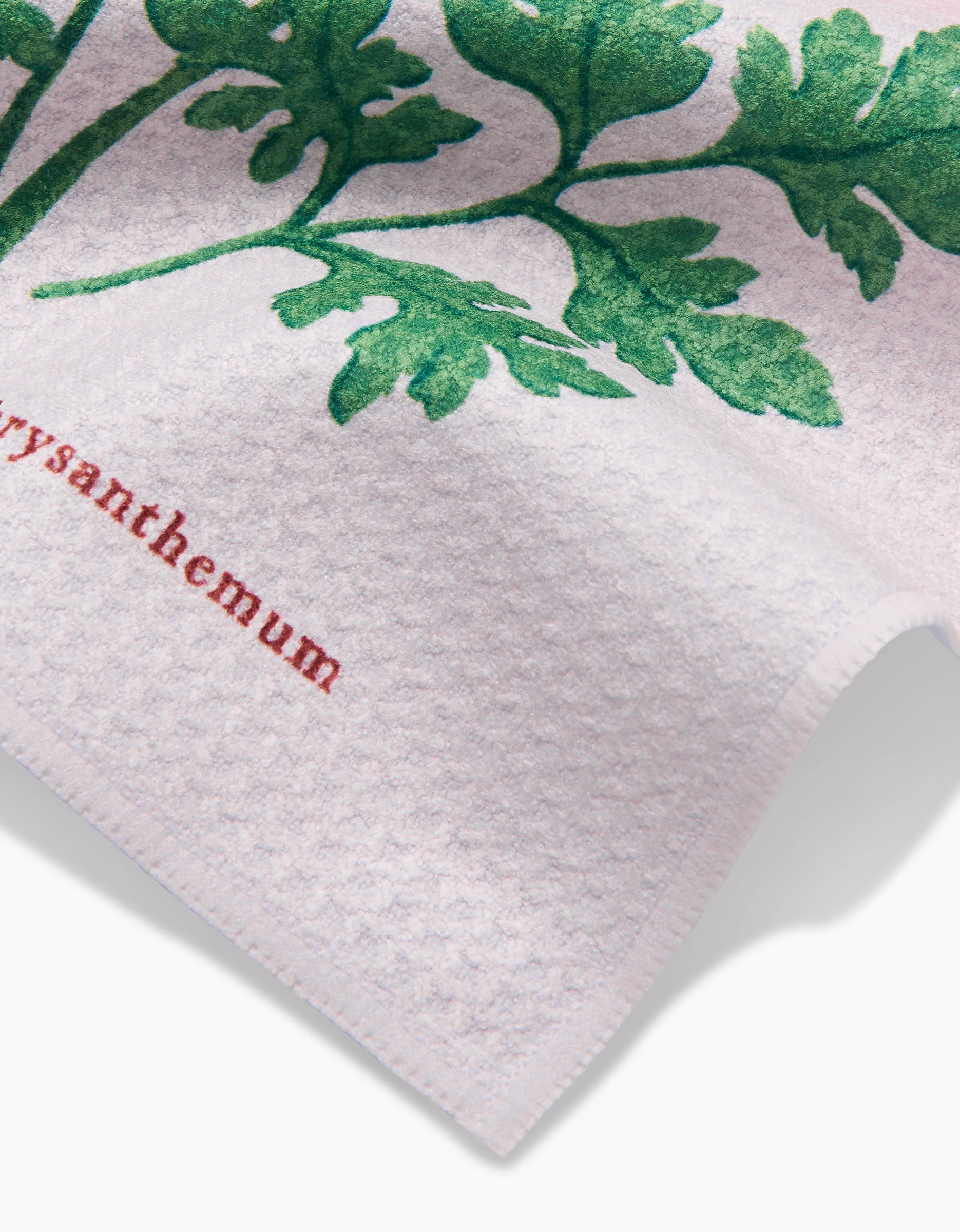 The Linda Fox November Chrysanthemum is a white textured Geoweave dishcloth featuring a green chrysanthemum stem and leaves illustration with chrysanthemum in red text below.