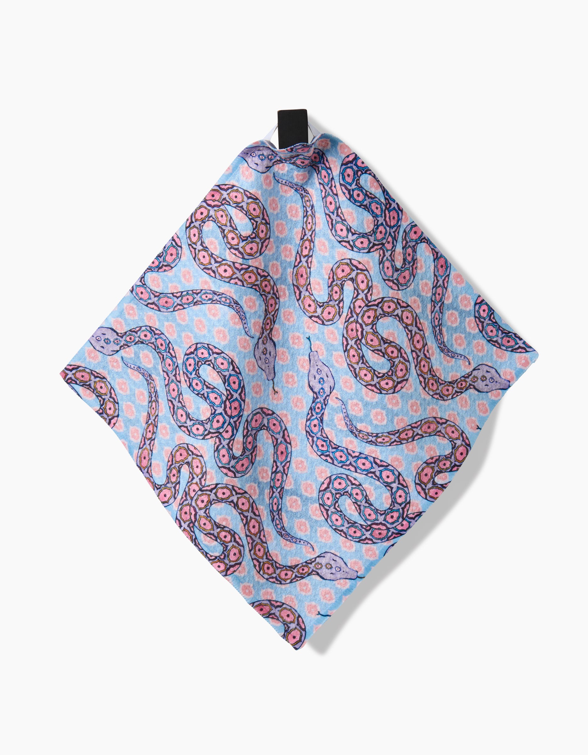 The Ophidia pocket square by Maayan Alper-Swan is made from soft Geoweave fabric, featuring swirling paisley in pink, purple, and blue on light blue, and hangs from a black tab against a white background.