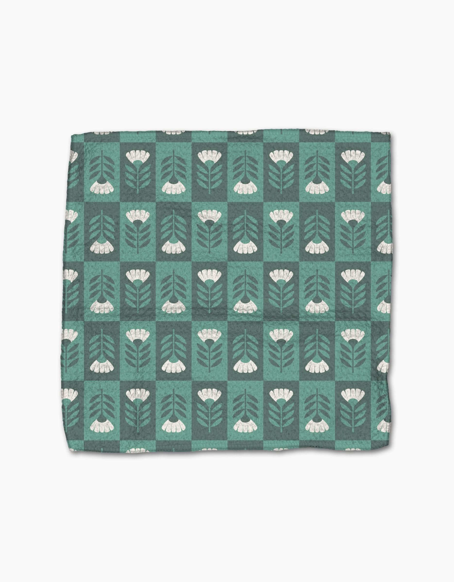 The Park Lane dishcloth by Charlie Rowan Designs is green with a grid of white flowers, stems, and leaves on a darker green background. Made from super-absorbent Geoweave fabric for efficient cleaning.