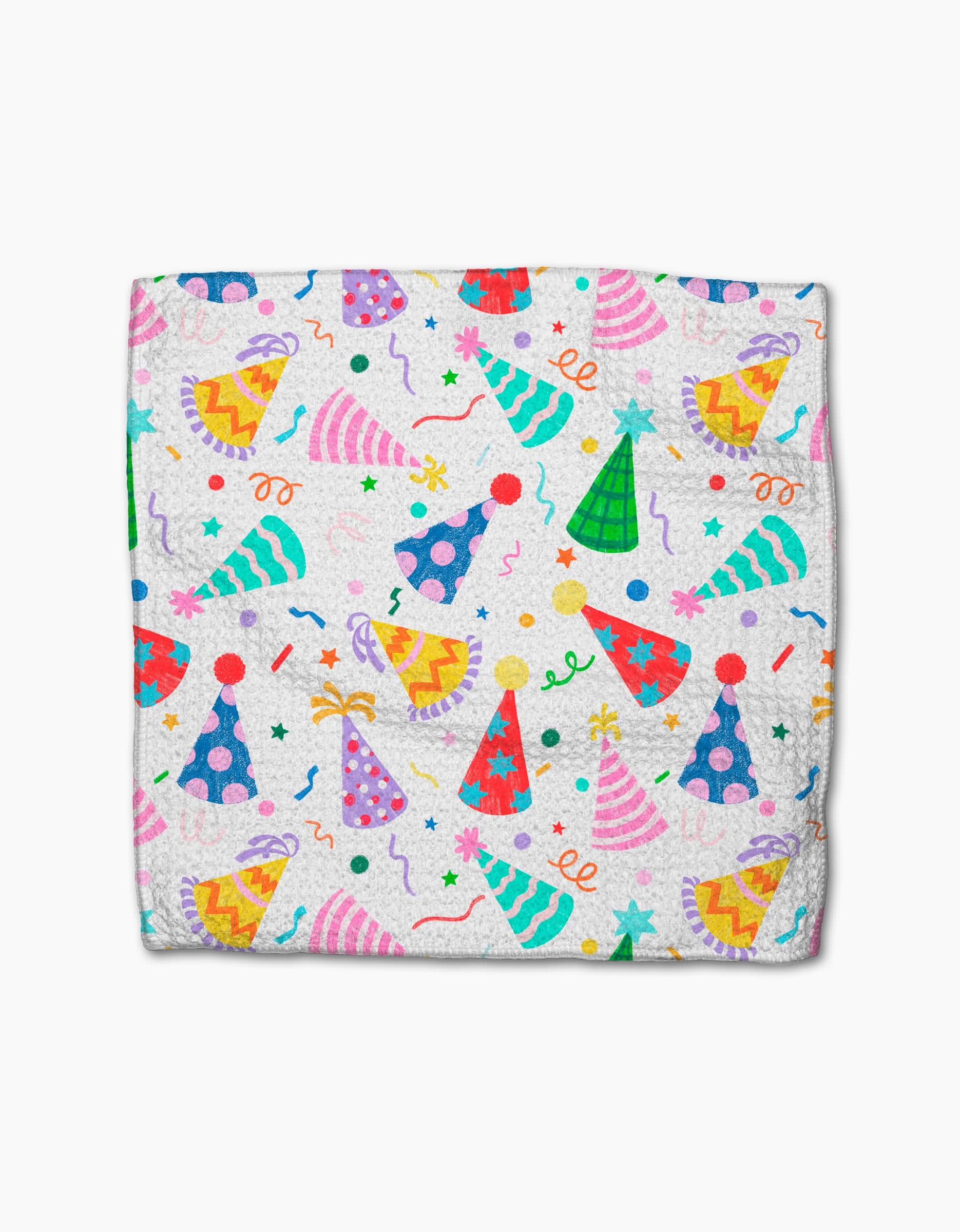 Party Pop by Vaishali Design Studio is a folded white blanket made from eco-friendly Geoweave fabric, featuring pink, blue, green, and yellow party hats with stars, confetti, and streamers scattered across the surface.