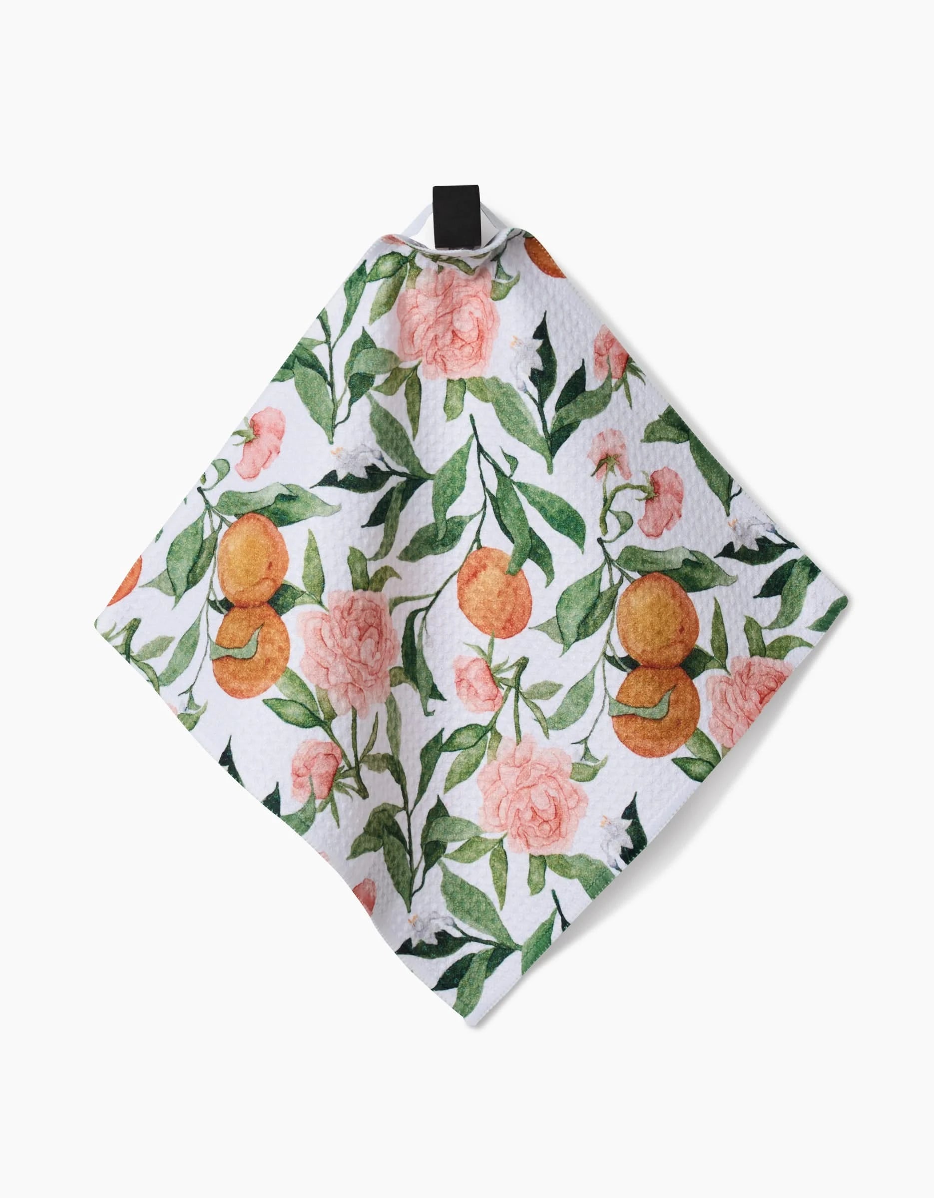 The Aubrey Fairchild Peony For Your Thoughts cloth is made with white Geoweave fabric and features a vibrant print of pink peonies, orange citrus fruits, and green leaves, plus a black hanging loop at the top.