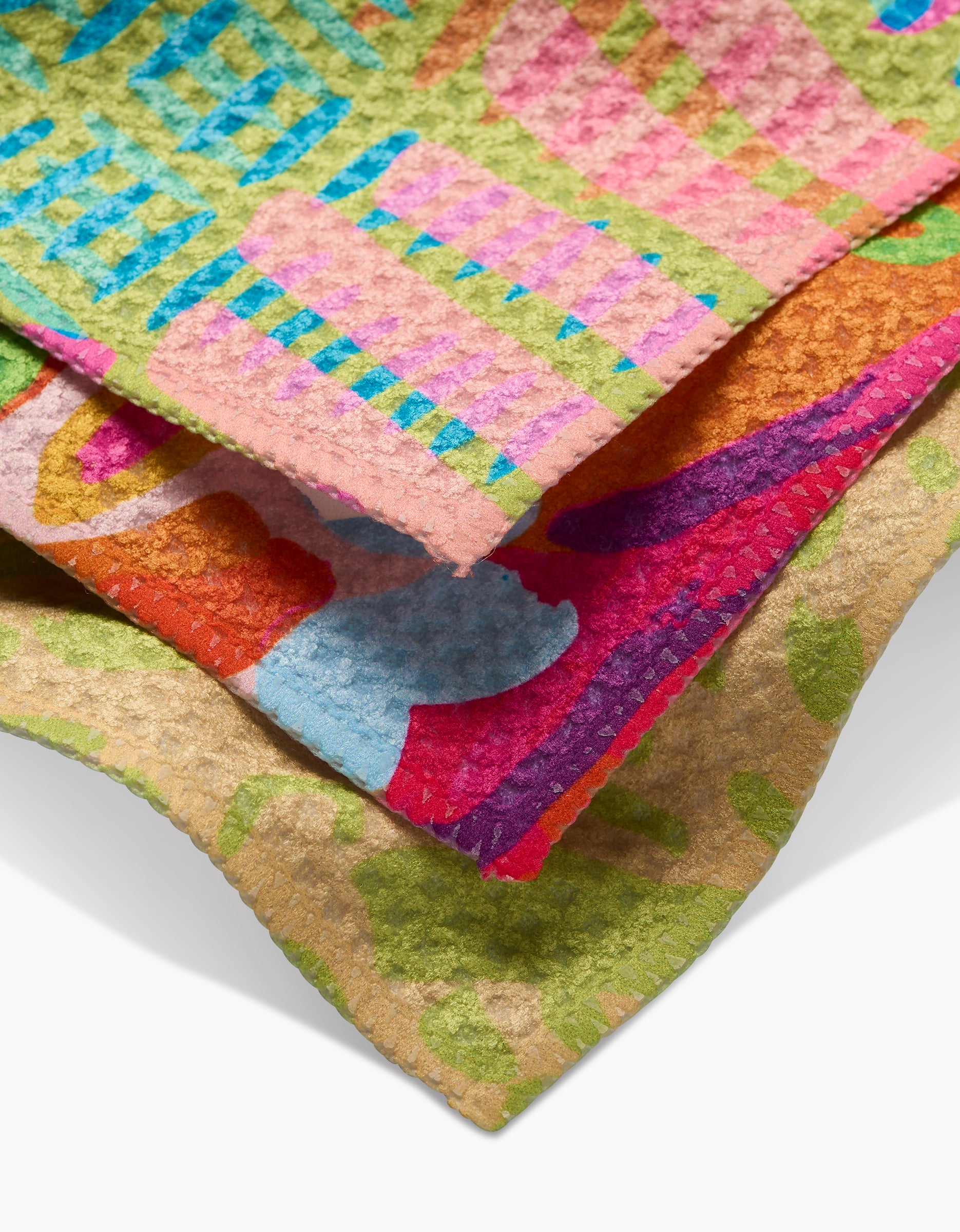 A close-up of vibrant, overlapping textured fabric pieces from Sareka Unique’s Positive Vibes collection, featuring recycled materials and colorful blue, pink, red, green, and yellow abstract geometric designs.